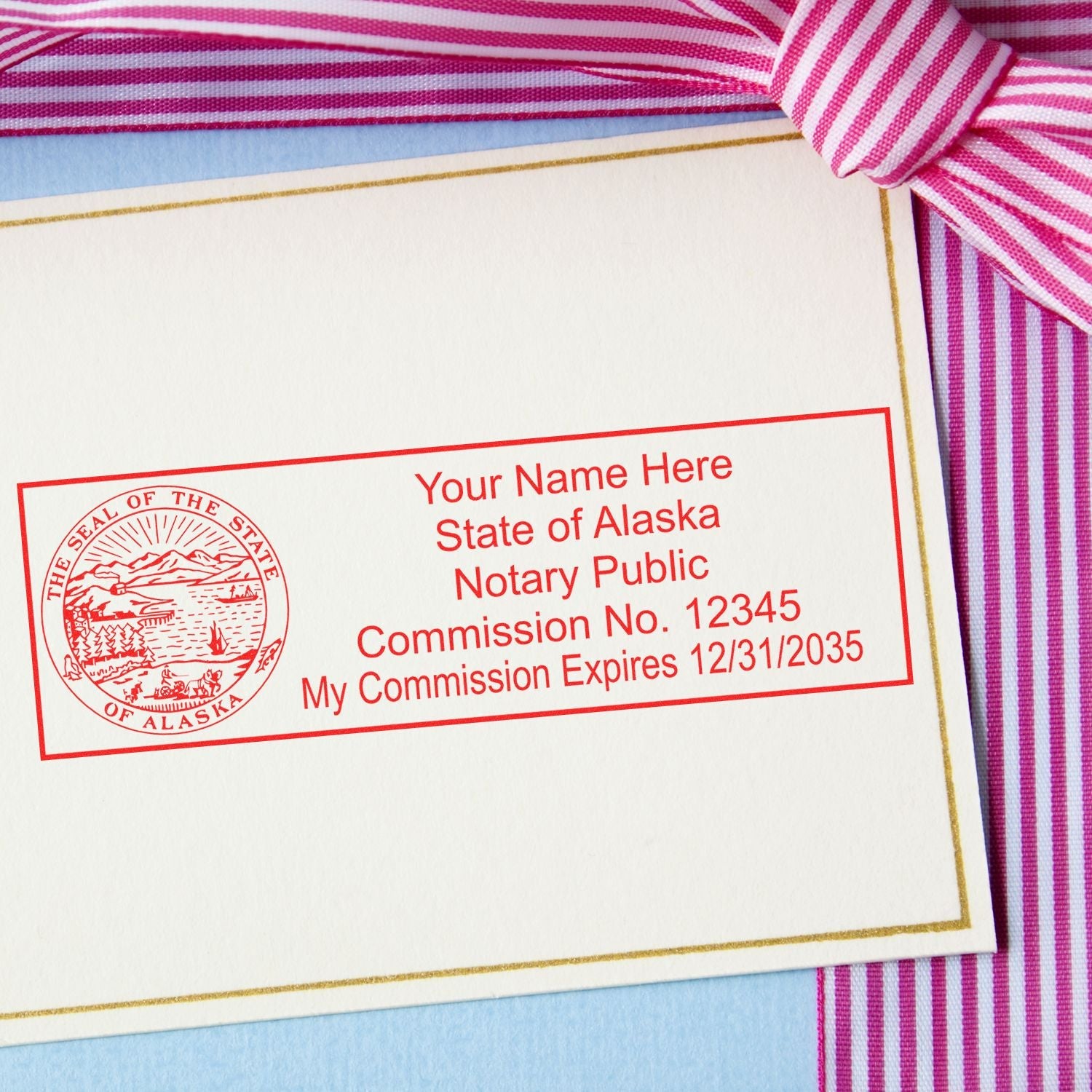 Notary Power Unleashed: The Best Alaska Notary Stamps for You Feature Image - Alaska notary stamp on a card with a striped ribbon.