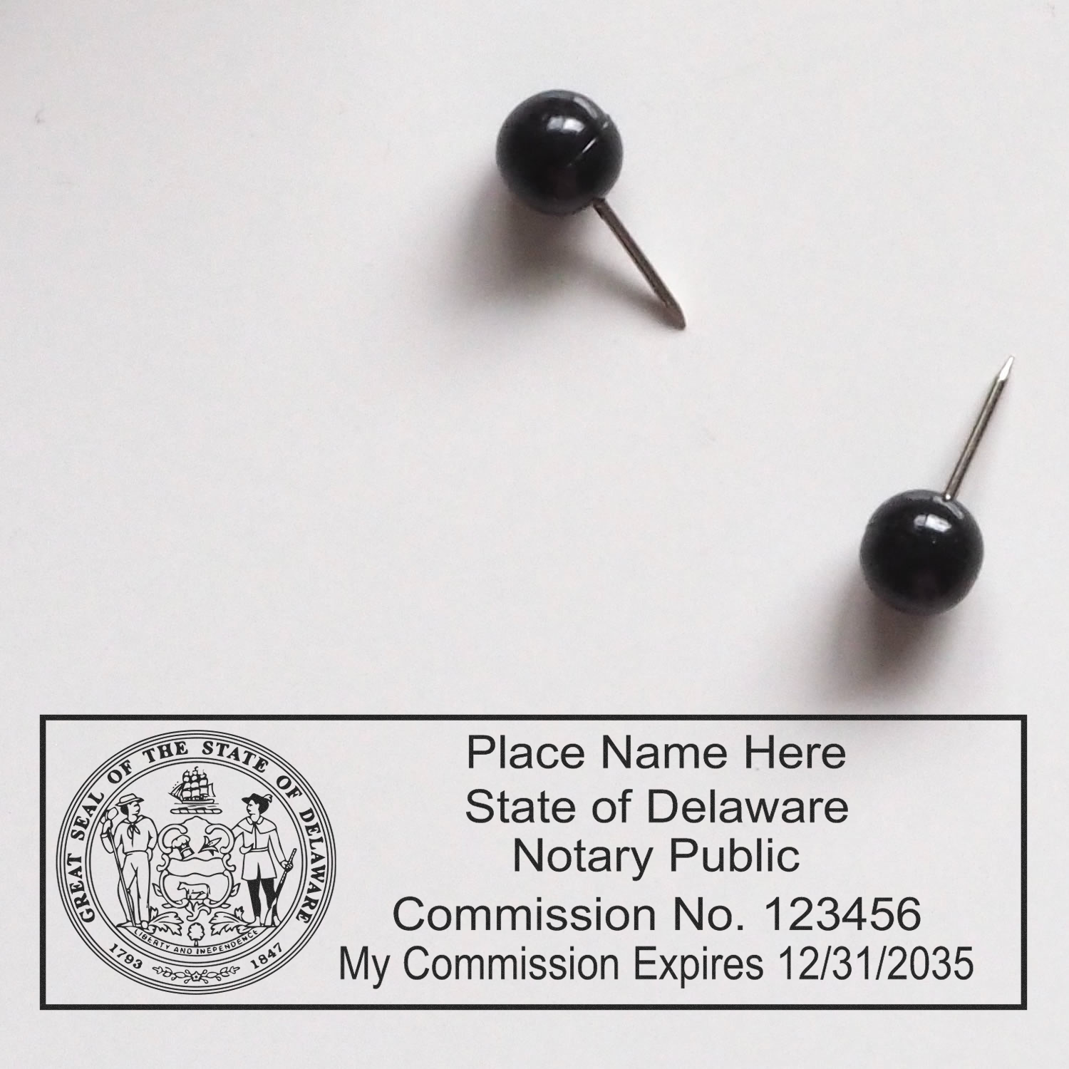 Image of Delaware Notary Public seal and commission details with two black push pins. Delaware Notary Supplies Blog Post Feature Image.