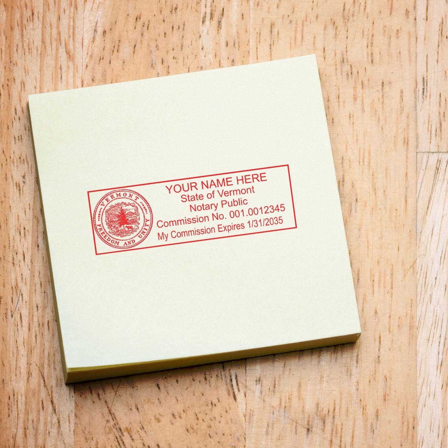 Vermont Notary Supplies Blog Post Feature Image: A rectangular notary stamp with red ink on a yellow sticky note on a wooden surface.