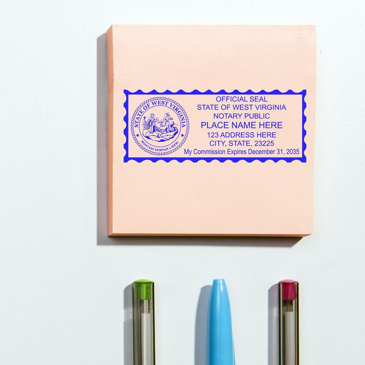 West Virginia Notary Supplies Blog Post Feature Image: Notary public stamp on a pink paper with pens and a blue pen cap nearby.