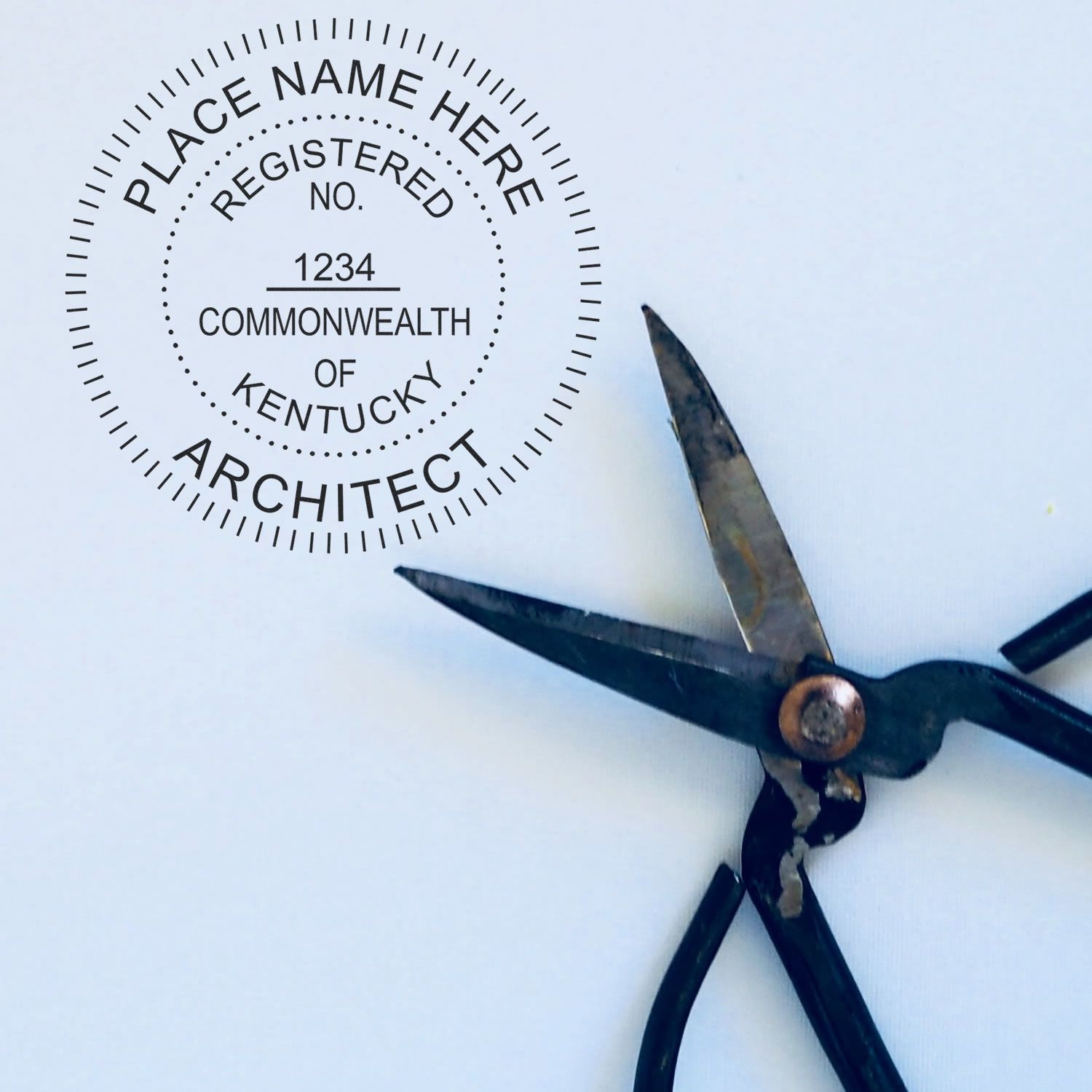 Image of a Kentucky architect stamp next to a pair of scissors. Blog post: Kentucky Architect Stamps 101: Everything You Need to Know Feature Image.