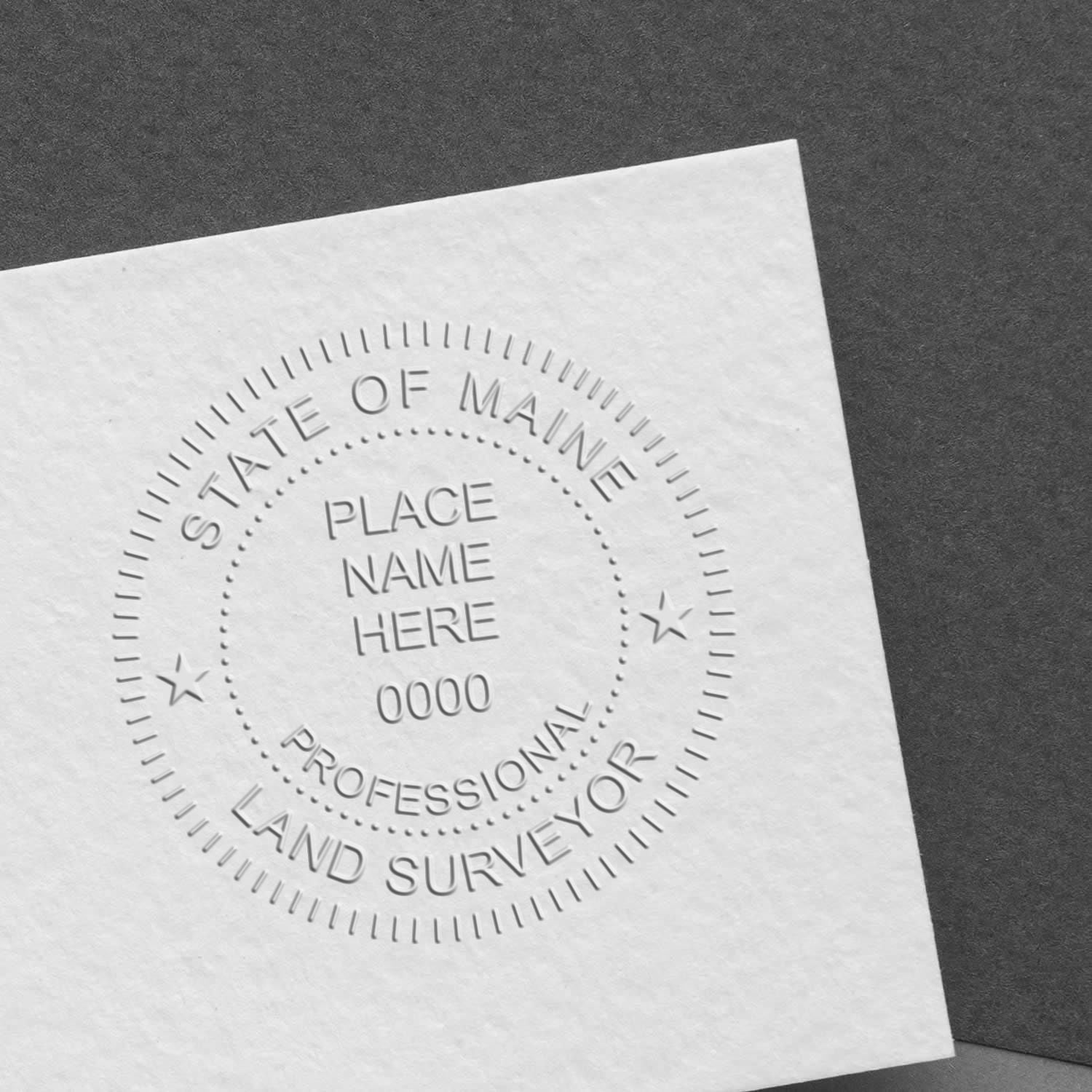 Embossed seal on white paper with text 'State of Maine Professional Land Surveyor'. Blog post: Maine Land Surveyor Stamp.