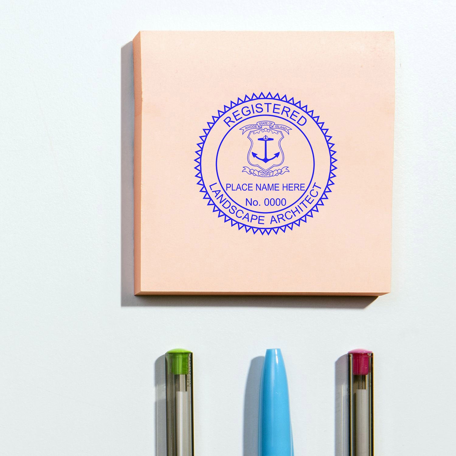 Rhode Island Landscape Architect Feature Image: A registered landscape architect seal stamp on a pink notepad with pens below.