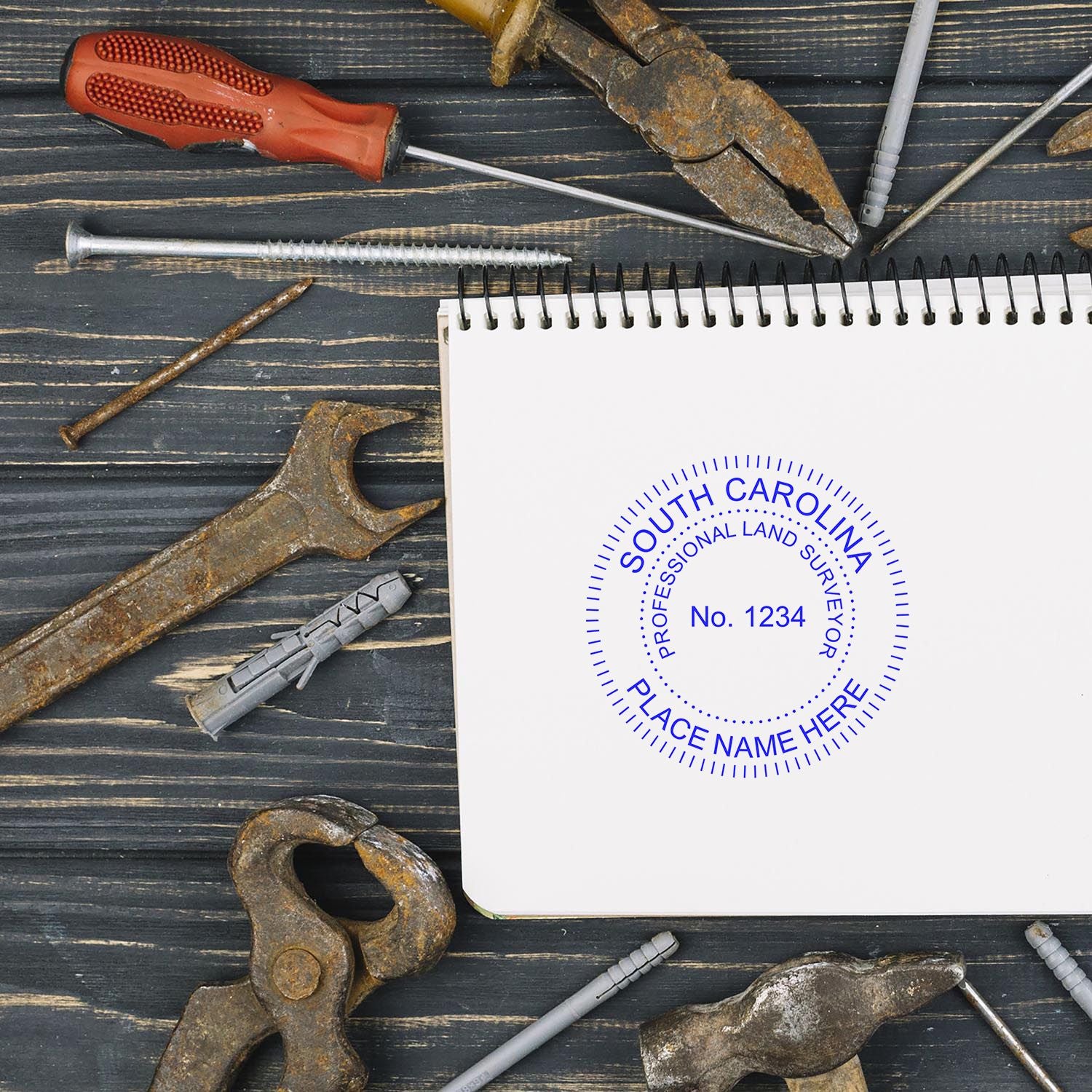 South Carolina Land Surveyor Stamp blog post: A stamped notebook surrounded by various rusty tools on a wooden surface.