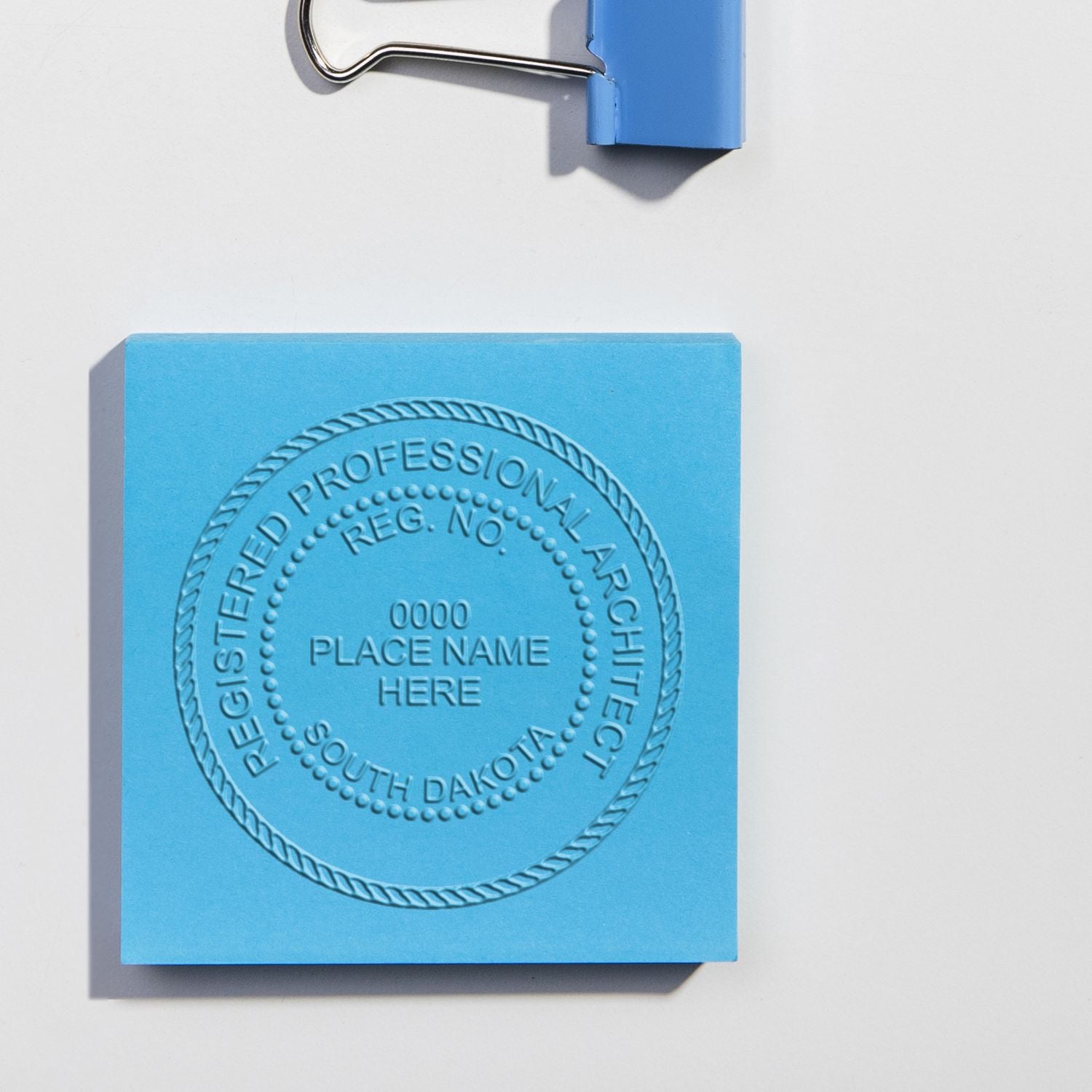 South Dakota Architectural Seals blog post: Blue embossed seal for a registered professional architect with a binder clip.