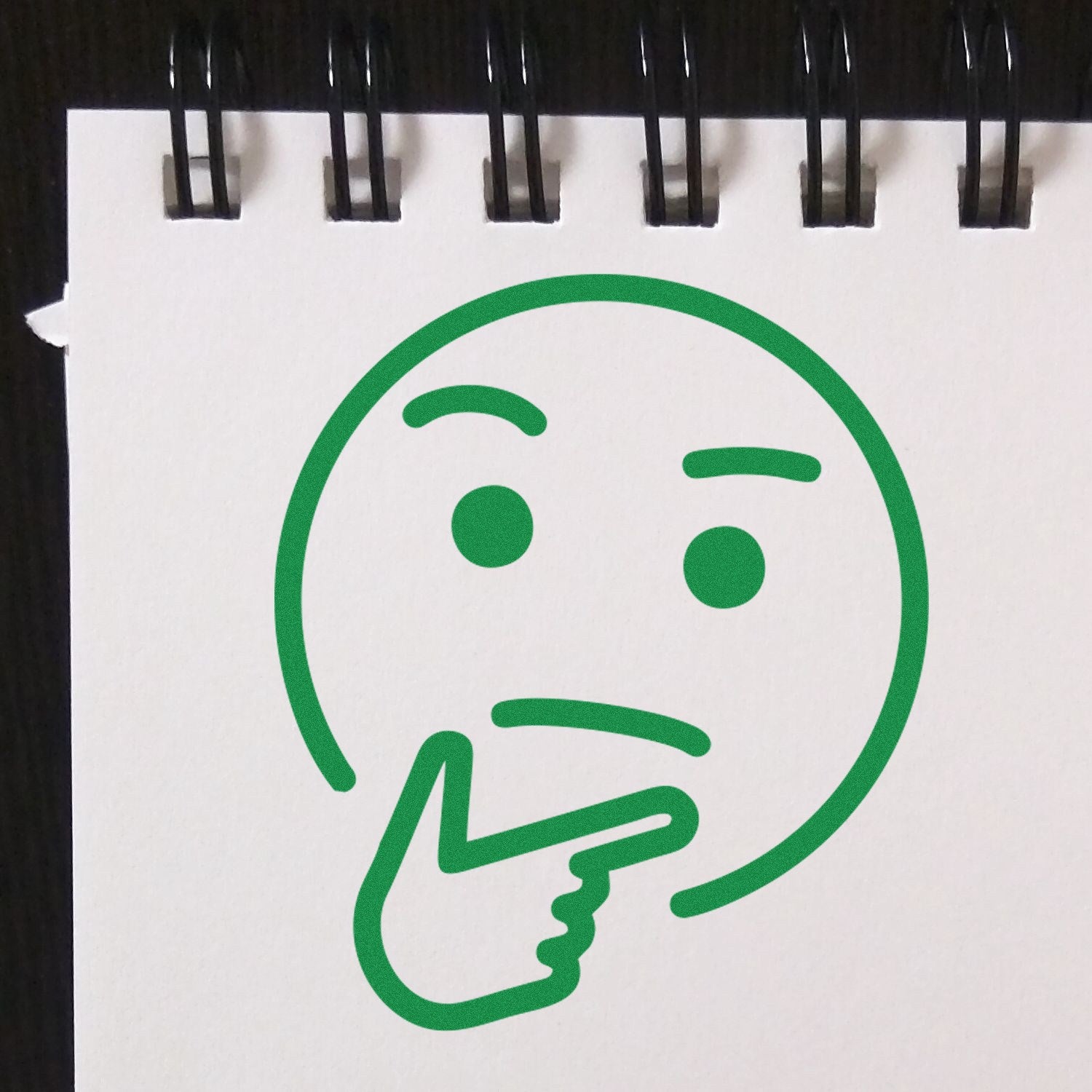 Self-Inking Pondering Pete Emoji Stamp imprint on white paper, featuring a green thinking face with a hand on chin. Ideal for adding thoughtful expressions to documents.