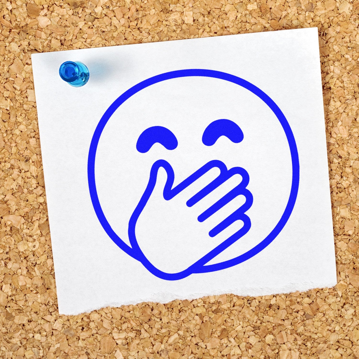 Self-Inking Giggling Gus Emoji Stamp on corkboard, featuring a blue laughing emoji with a hand over its mouth, pinned to a note. Perfect for adding fun to any project.