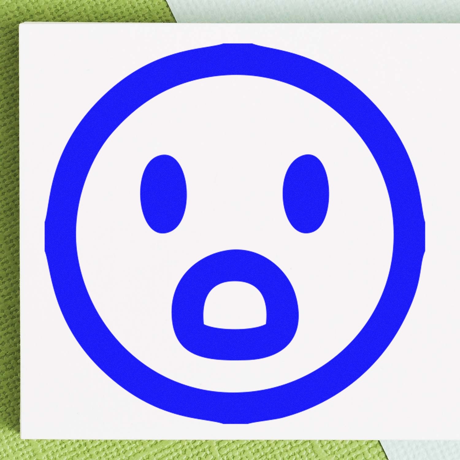 Self-Inking Surprised Sam Emotes Stamp with a blue surprised face design on a white background, perfect for adding expressive touches to your projects.