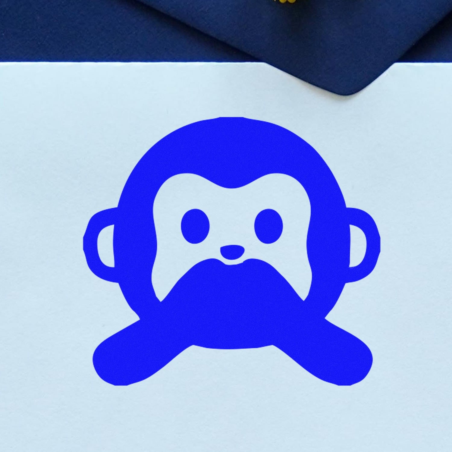 Wood Handle Mute Monkey Facial Expressions Rubber Stamp featuring a blue monkey face design on white paper, ideal for crafting and stationery projects.