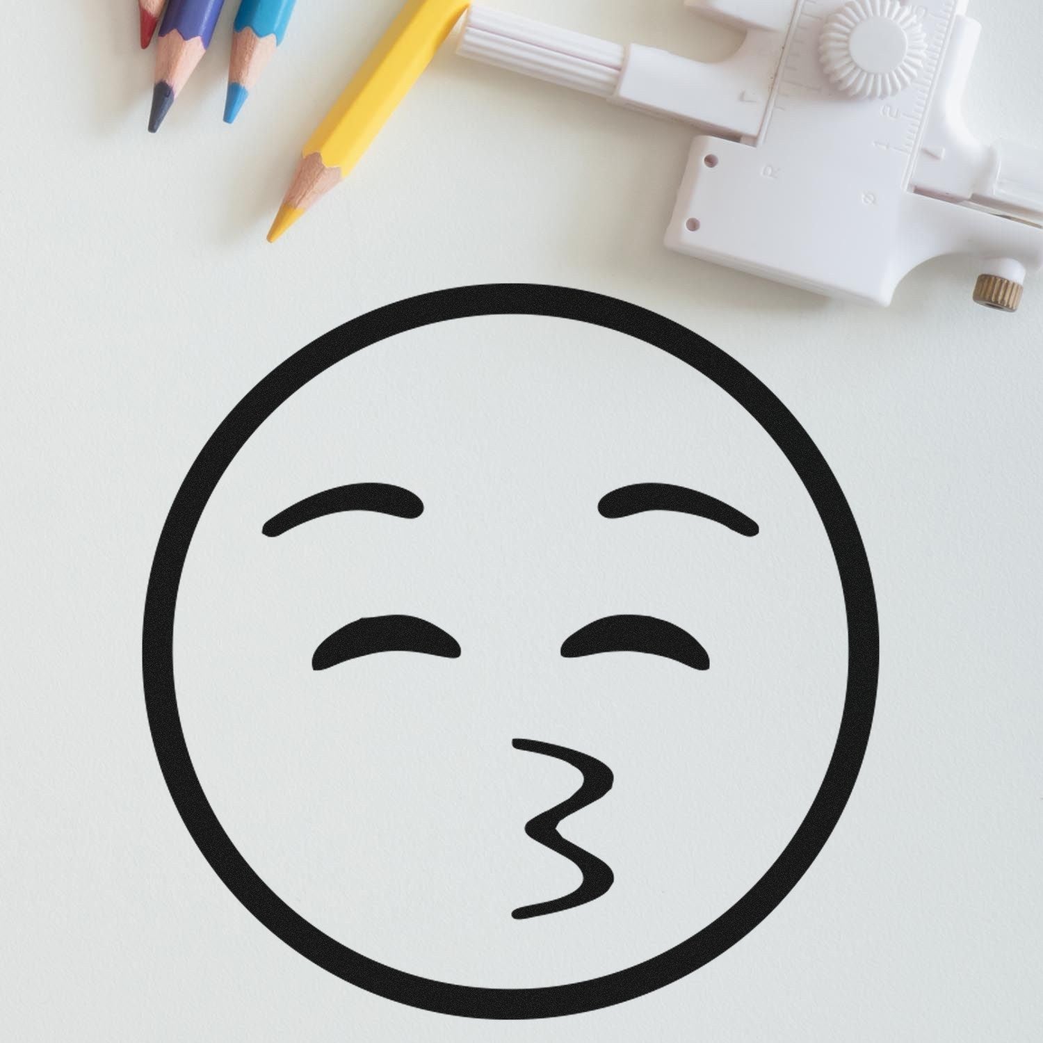 Wood Handle Whistling Willie Emoji Rubber Stamp on paper, featuring a playful whistling face design. Ideal for crafts and stationery. Includes wooden handle for easy use.