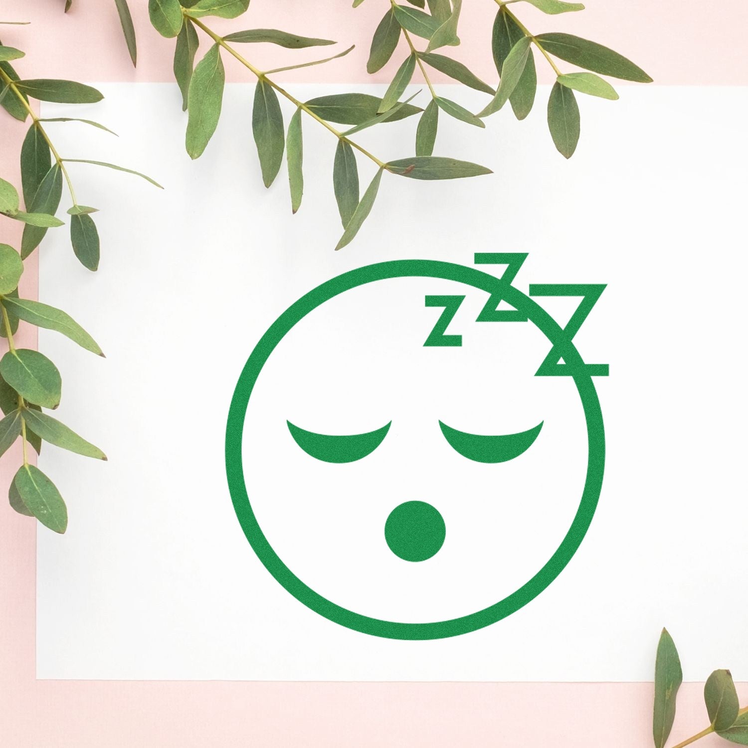 Wood Handle Sleepy Steve Reaction Rubber Stamp on paper, featuring a sleepy face with closed eyes and Zzz symbols, surrounded by green leaves on a light background.