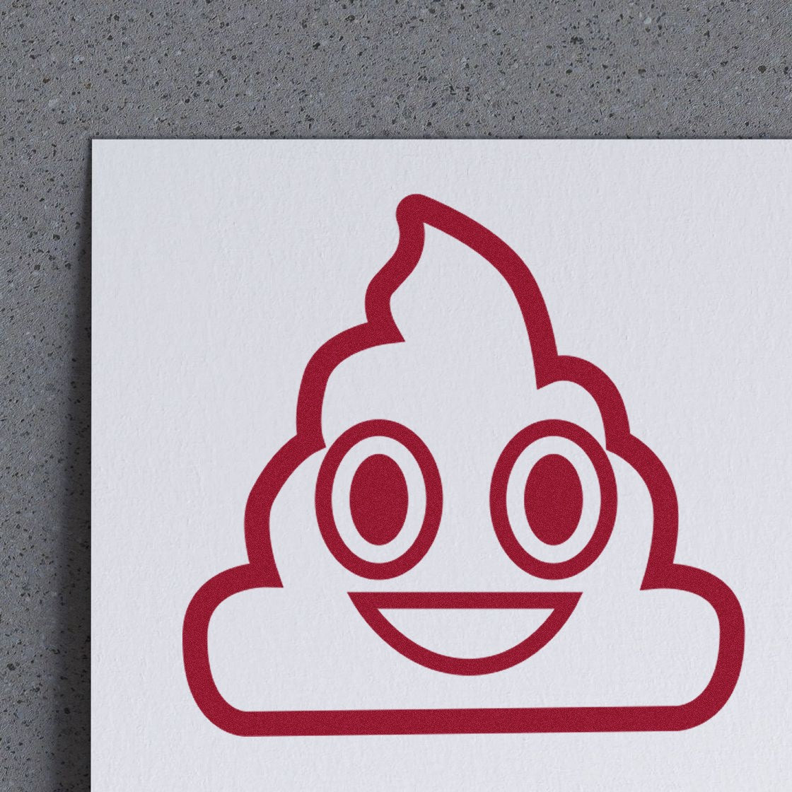 Wood Handle Smiling Poop Emojicons Rubber Stamp on paper, featuring a cheerful poop emoji design in red. Perfect for adding a playful touch to crafts and stationery.