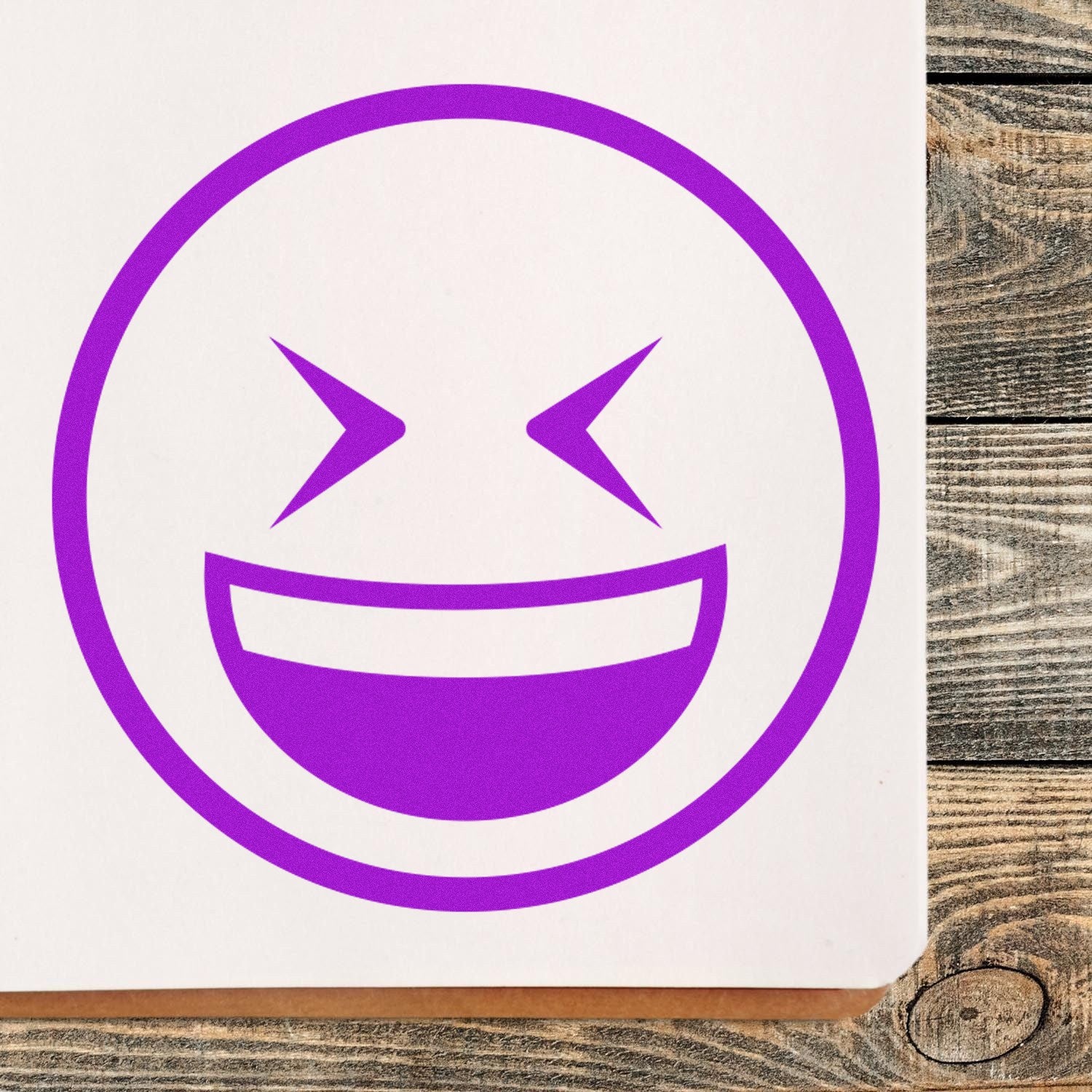 Self-Inking Excited Squint Emoji Stamp in purple ink on paper, featuring a playful, squinting smiley face design. Perfect for adding fun and personality to your projects.