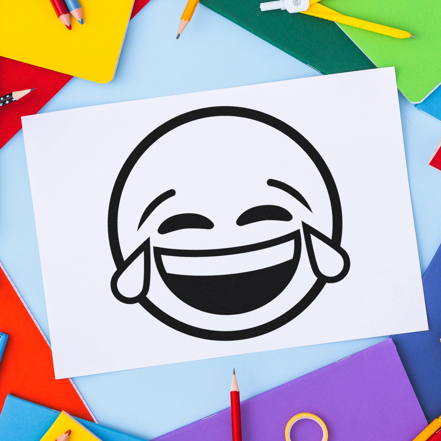 Wood Handle Tearful Giggles Emoji Rubber Stamp on colorful paper background, showcasing a laughing emoji with tears design. Perfect for adding fun to crafts and stationery.