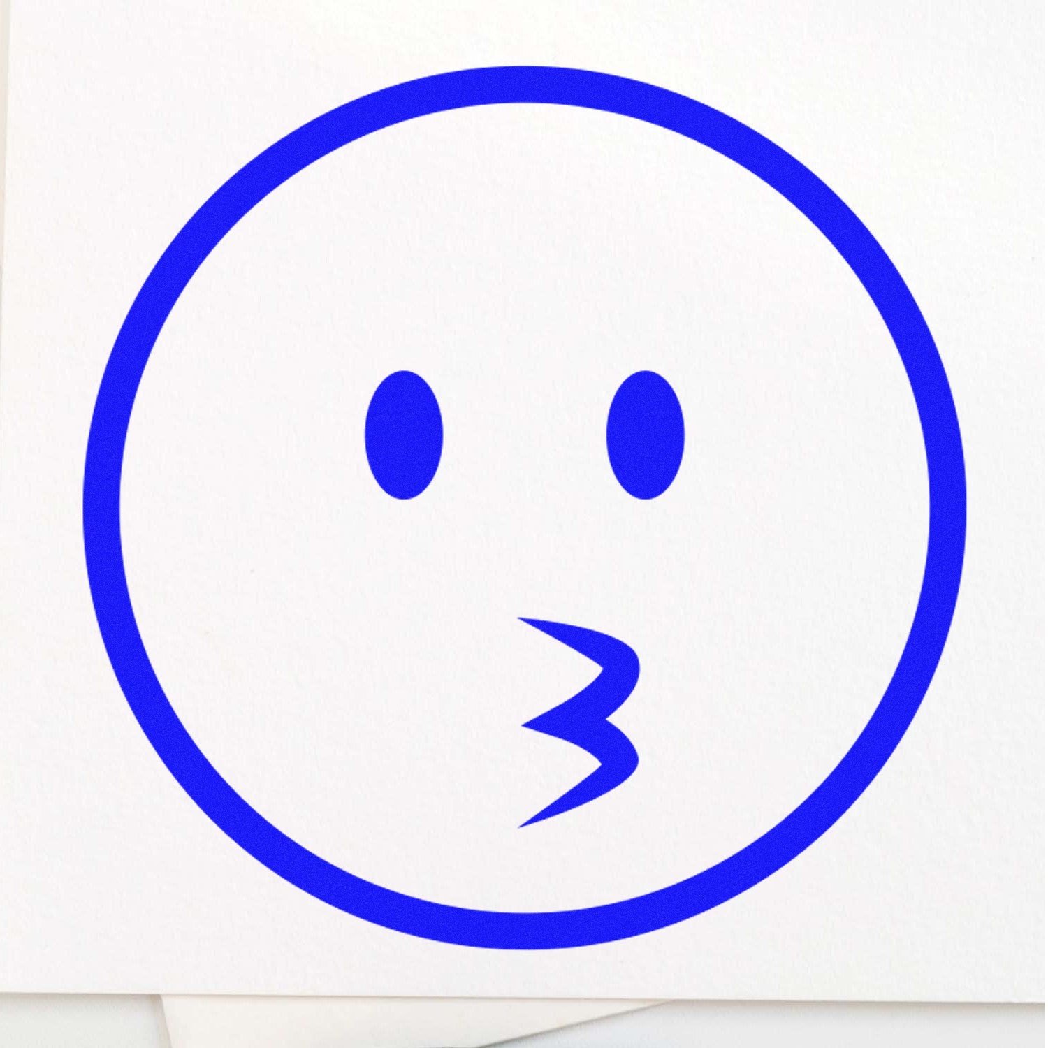 Self-Inking Whistling Wil Emojicons Stamp featuring a blue whistling face design on a white background, perfect for adding playful expressions to your projects.