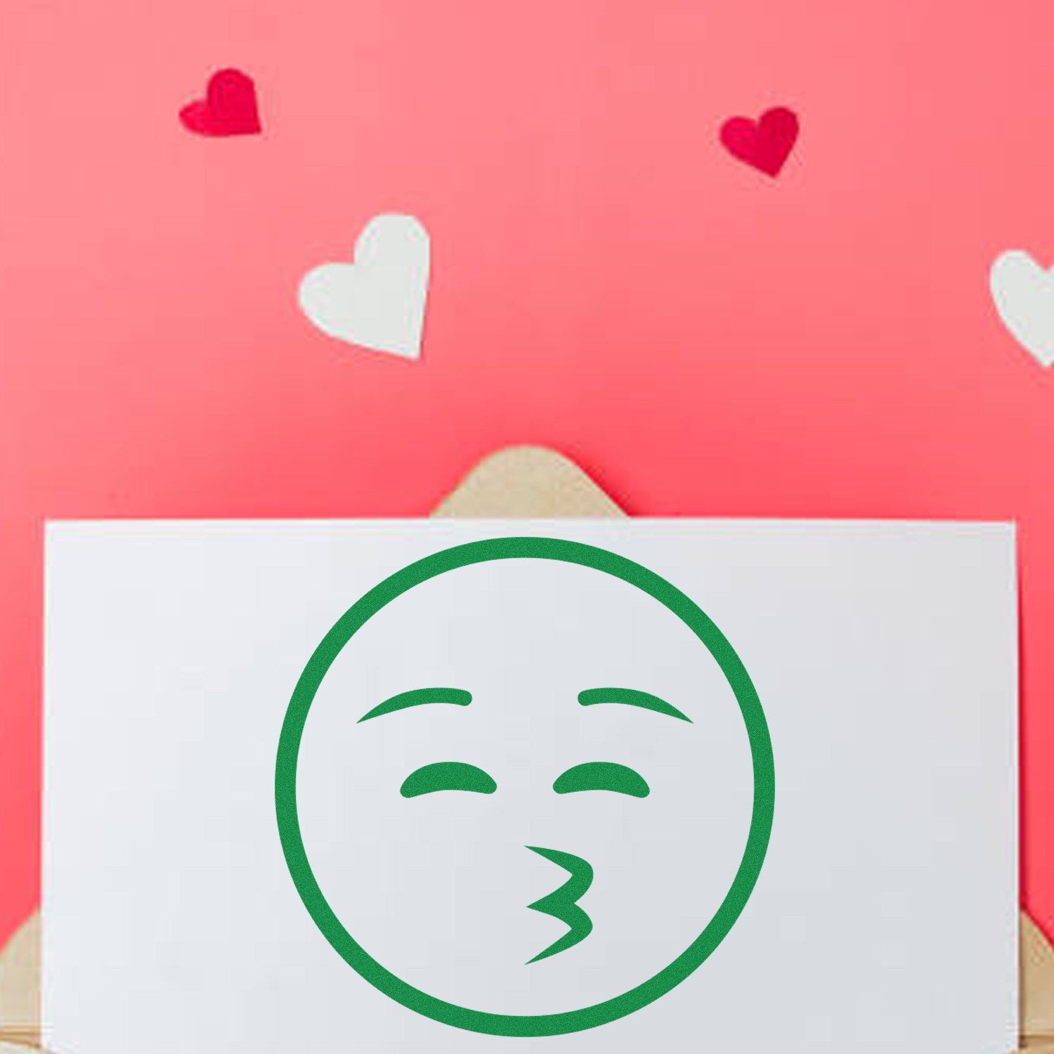 Wood Handle Whistling Wanderer Emoji Rubber Stamp on a pink background with red and white hearts. Features a green whistling emoji design, perfect for crafting and personalizing stationery.