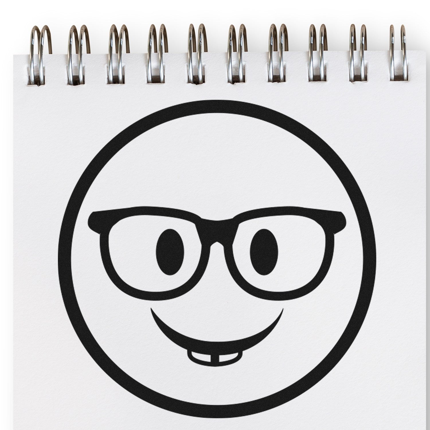 Wood Handle Wise Guy Smiley Rubber Stamp featuring a smiling face with glasses, stamped on a spiral notebook. Perfect for adding a playful touch to your stationery or crafts.