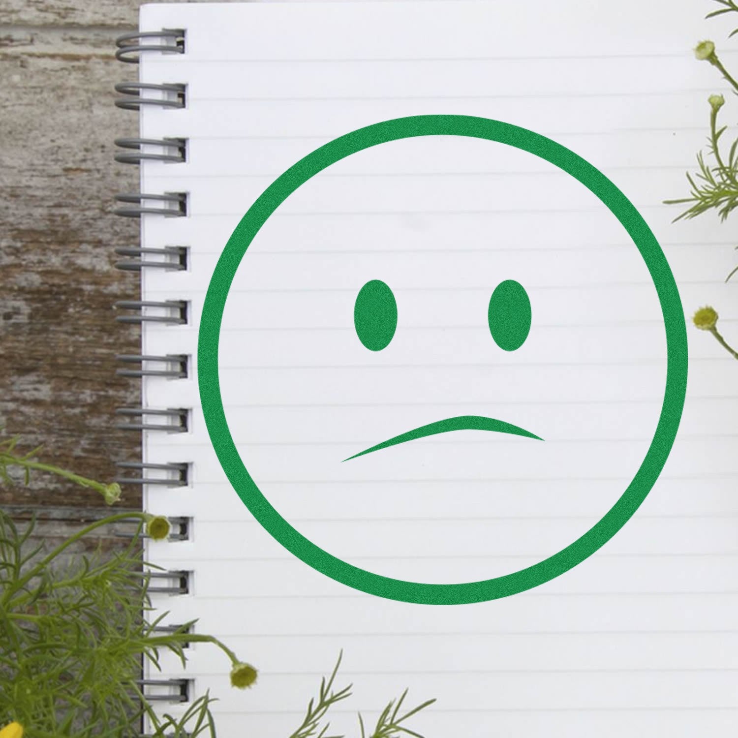 Self-Inking Solemn Simplicity Emoji Stamp on notebook page, featuring a green, simple frown face. Perfect for adding a touch of emotion to your notes or documents.