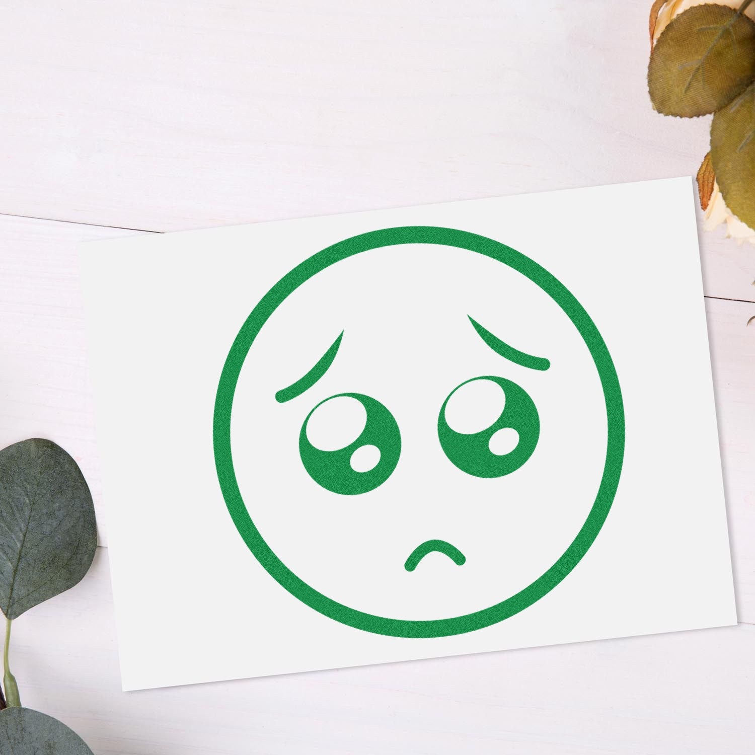 Wood Handle Puppy Eyes Emoji Rubber Stamp: A wooden-handled stamp featuring a cute, green puppy eyes emoji design, perfect for adding a playful touch to crafts and stationery.