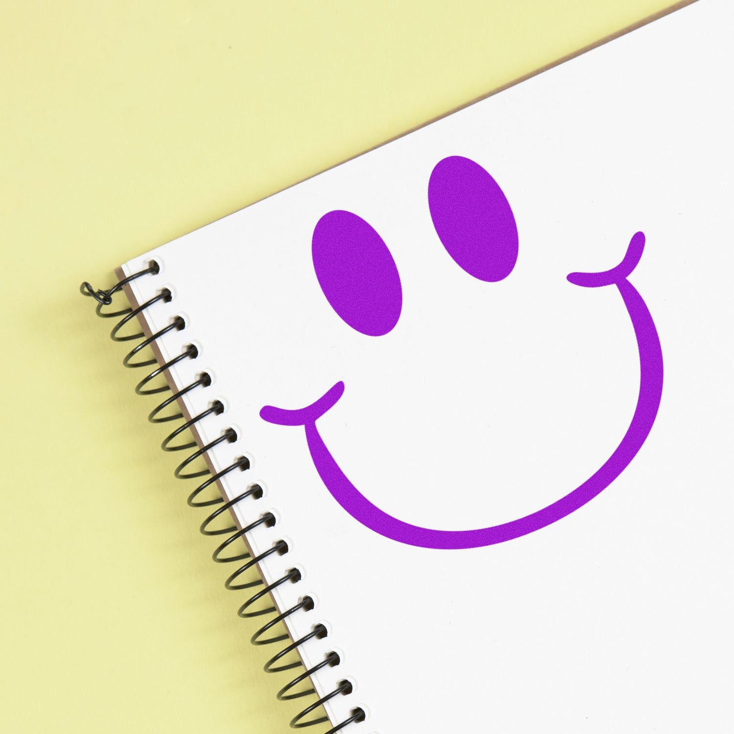 Wood Handle Playful Smirk Reaction Rubber Stamp imprint on notebook, featuring a purple smirk face design. Ideal for adding fun, expressive touches to stationery and crafts.