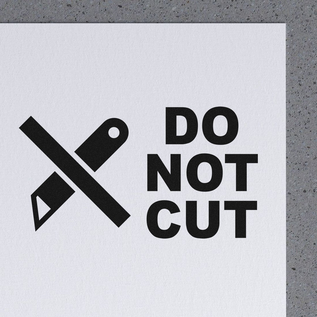 Slim Pre-Inked Do Not Cut Symbol Stamp on white paper, featuring a crossed-out knife icon and bold Do Not Cut text, ideal for packaging and shipping warnings.