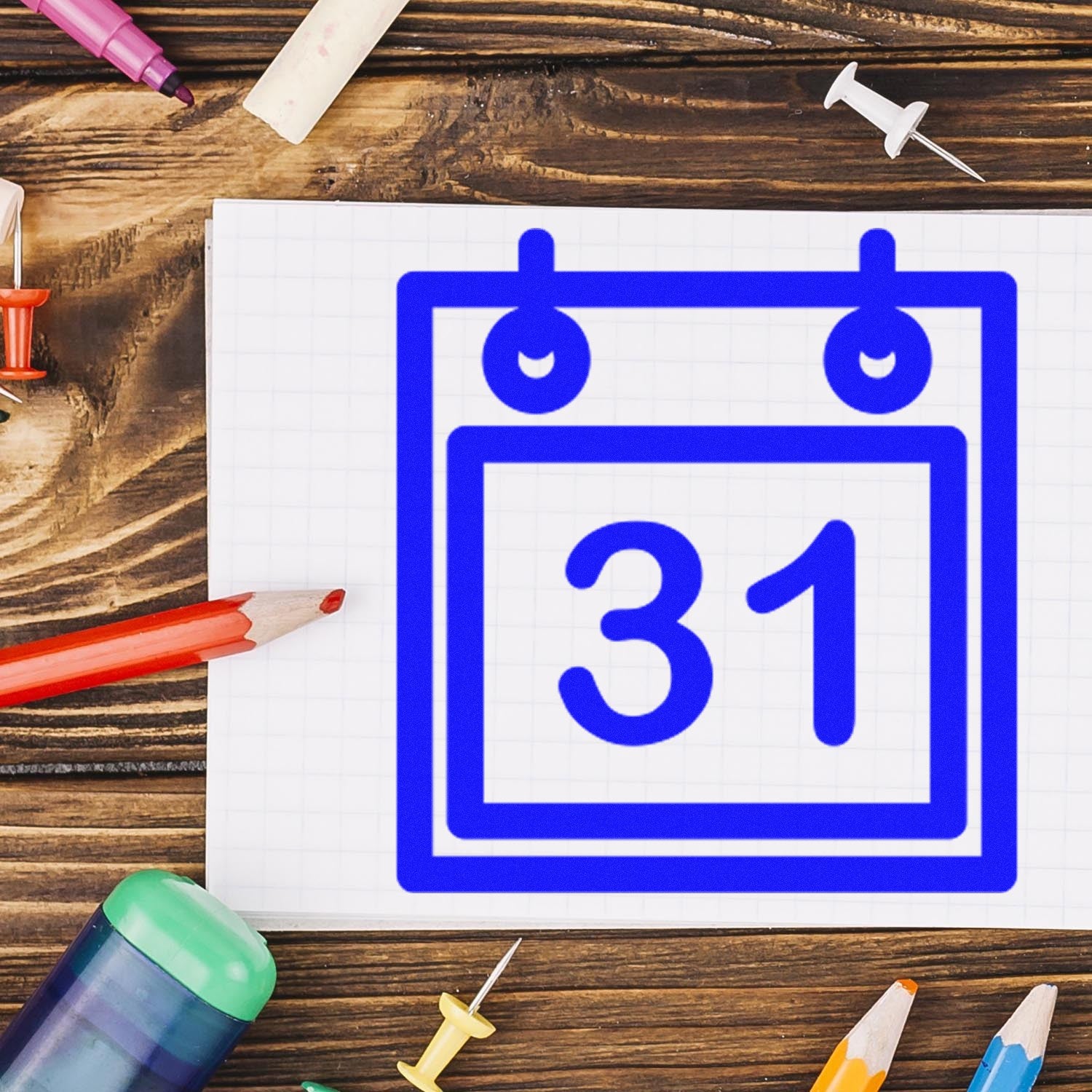 Self-Inking Monthly Loyalty Program Stamp with blue calendar design featuring the number 31, displayed on a wooden desk with stationery items.