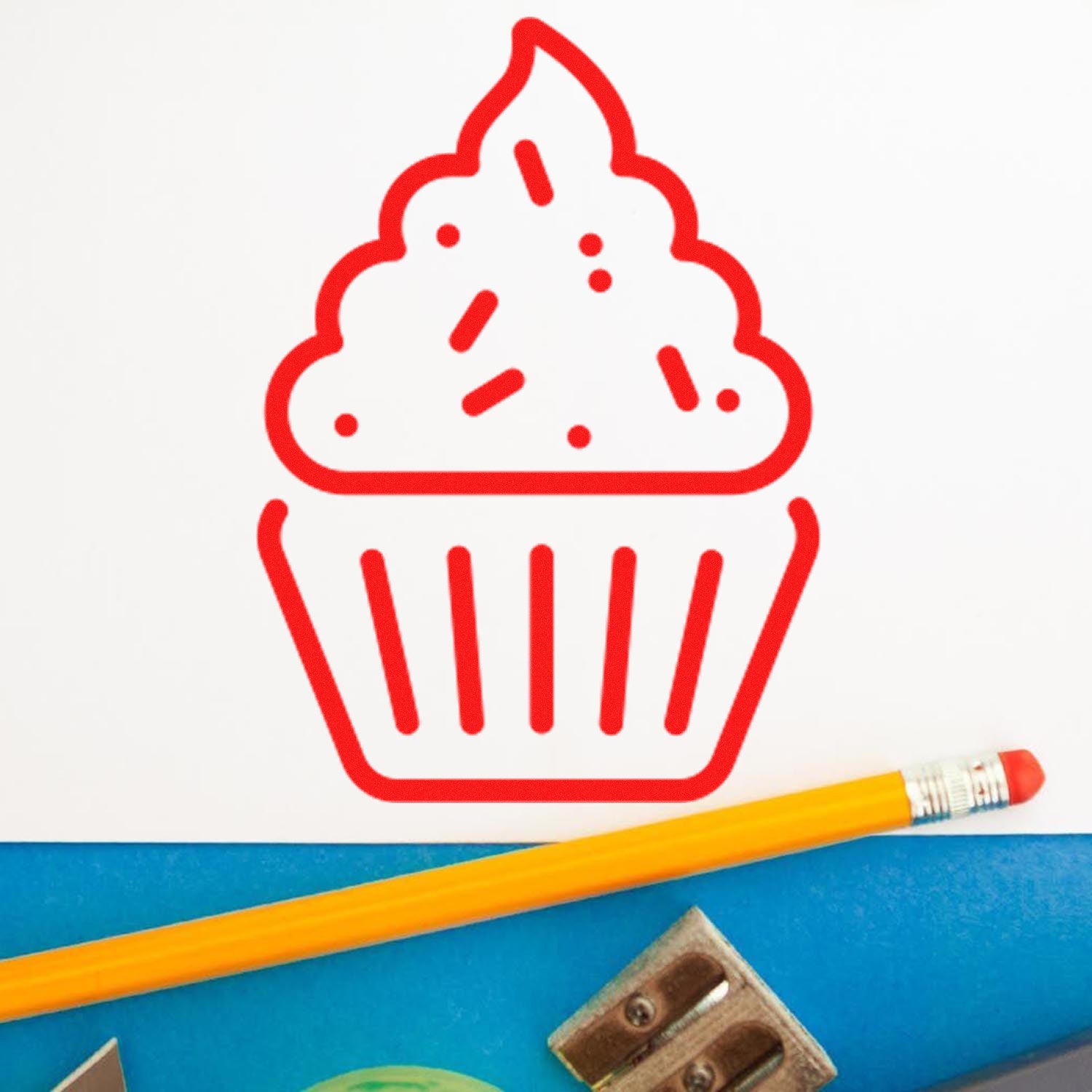 Wood Handle Happy Cupcakes Card Reward Rubber Stamp featuring a red cupcake design on white paper, with a pencil and sharpener nearby.