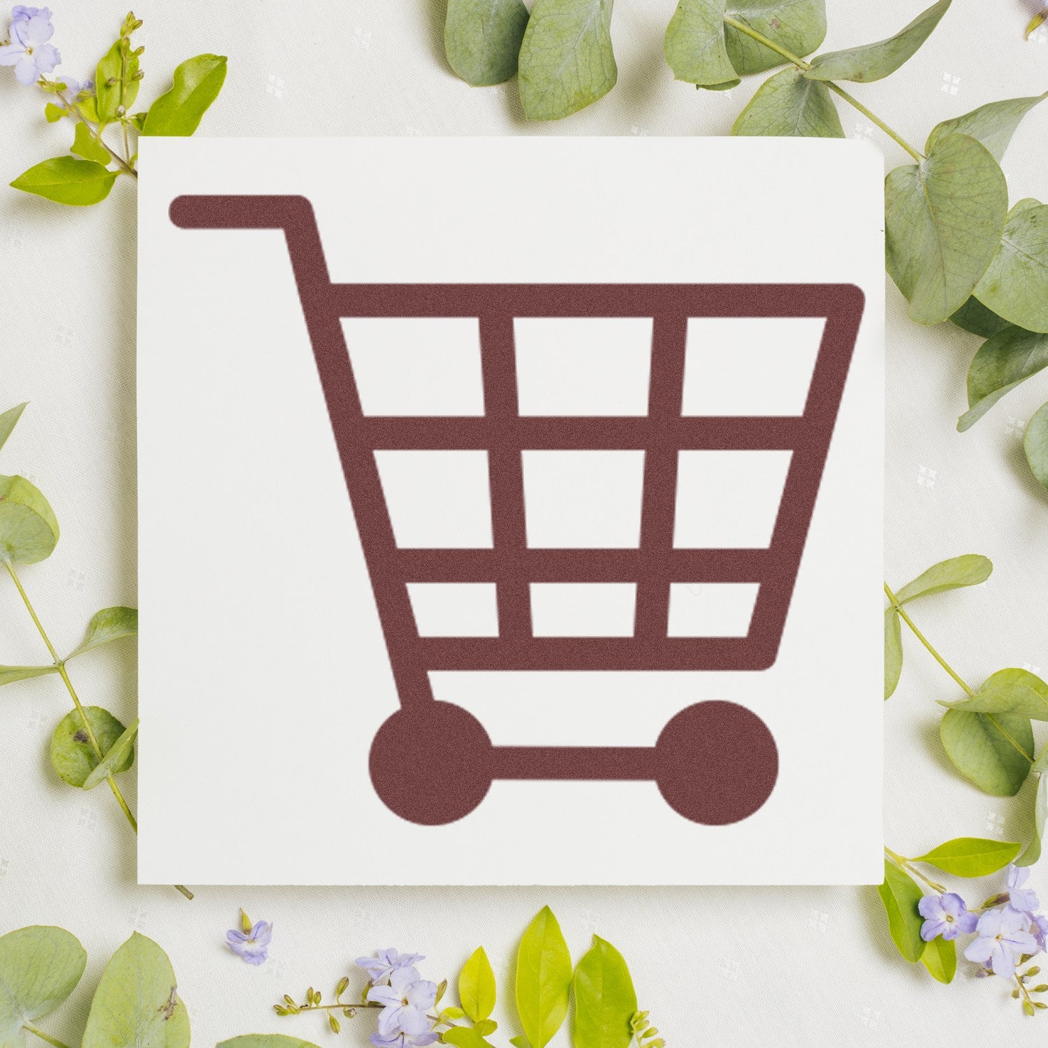 Image of the Self-Inking Shopper's Delight Discount Stamp featuring a brown shopping cart icon on a white background, surrounded by green leaves and small purple flowers.