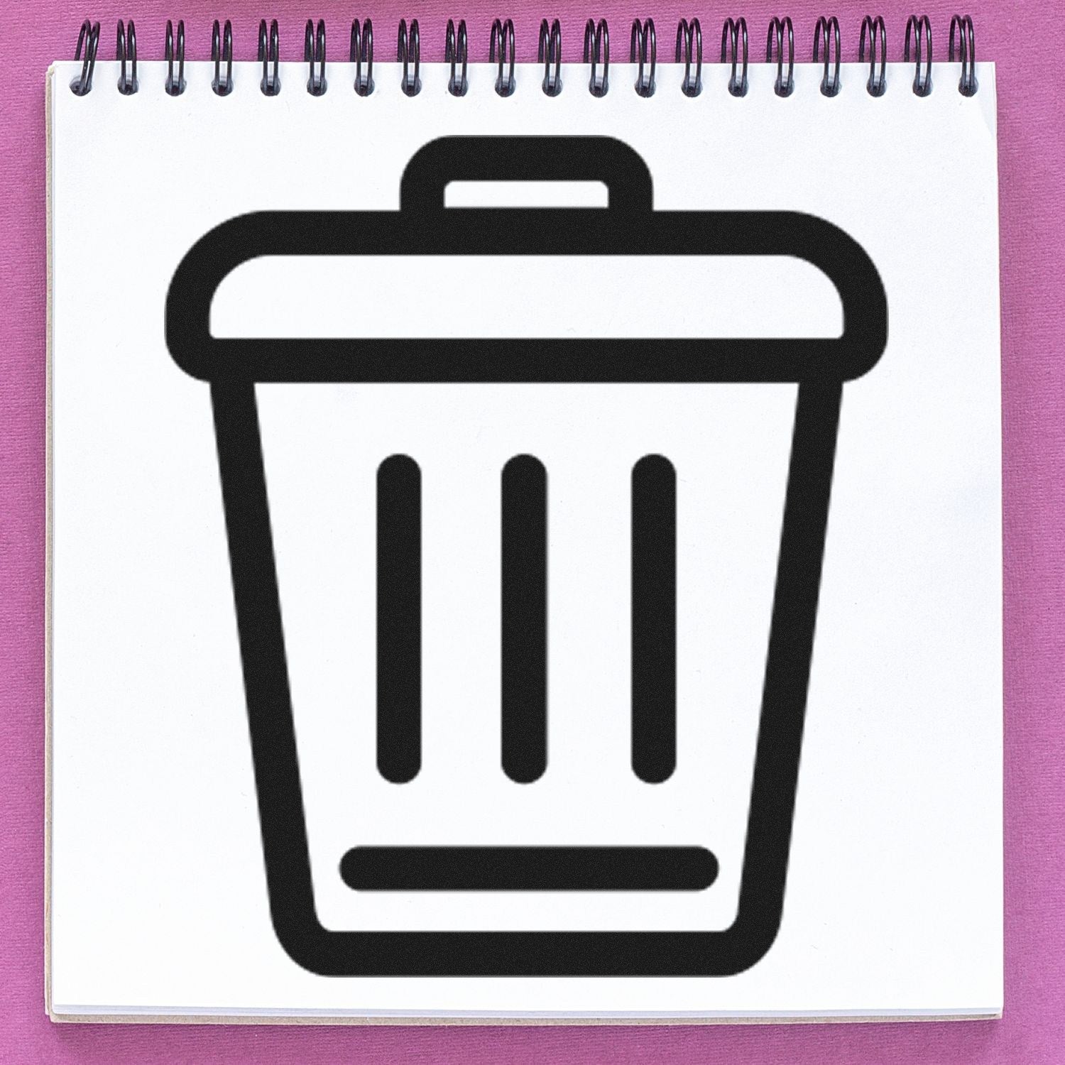 Self-Inking Clean World-Based Rewards Stamp with a trash can icon on a spiral notebook, showcasing eco-friendly design and functionality.