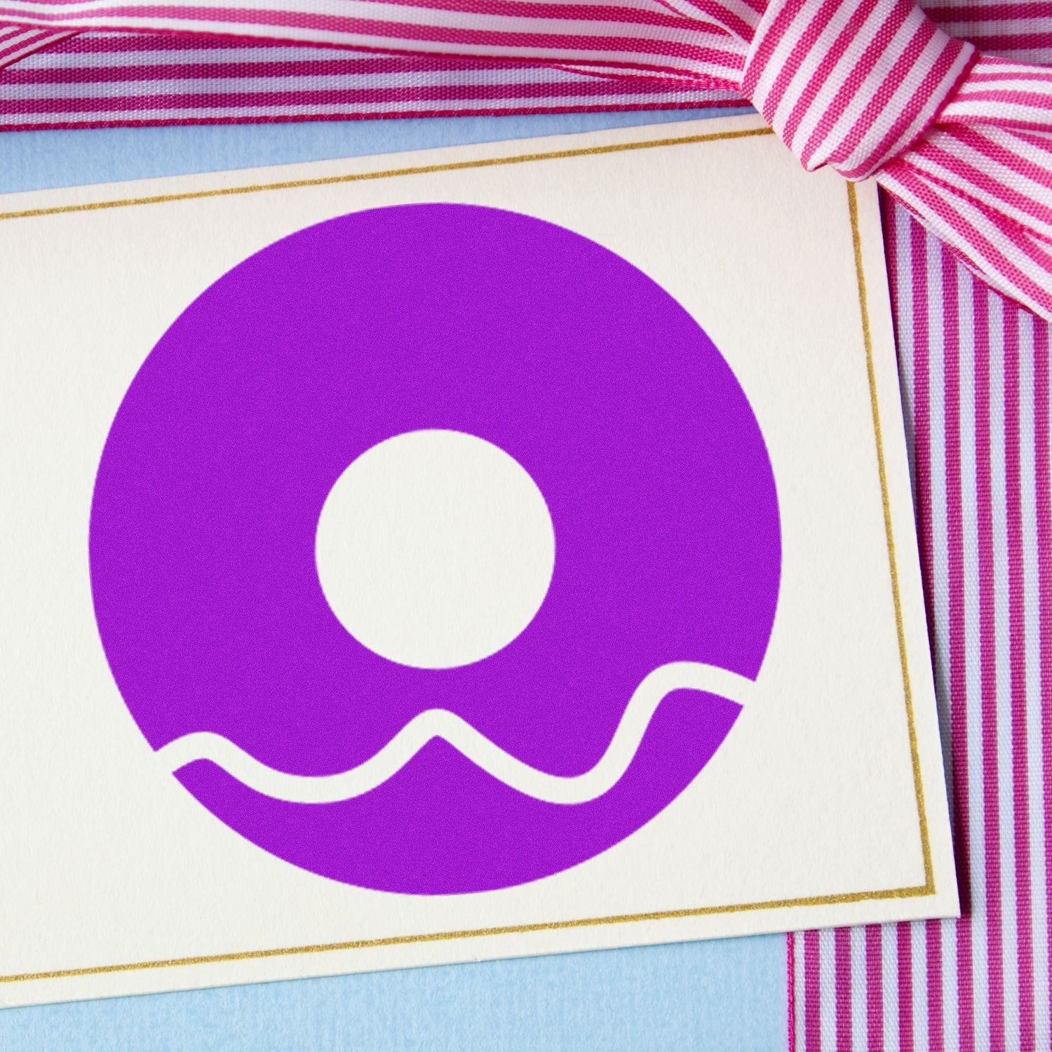 Image of the Self-Inking Donut Delight Customer Loyalty Stamp featuring a purple donut design on a card with a pink striped ribbon. Perfect for rewarding loyal customers.