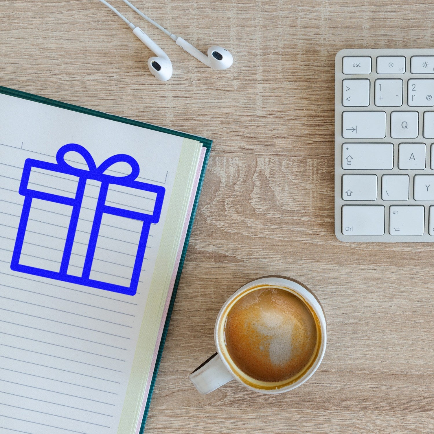 Self-Inking Gifts Galore Loyalty Points Stamp on a notepad with a blue gift icon, next to a coffee cup, keyboard, and earbuds on a wooden desk.