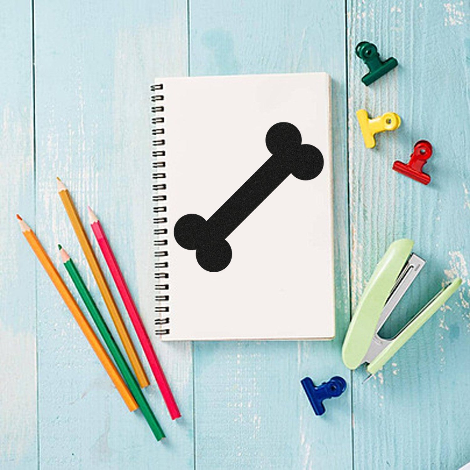 Self-Inking Bone-A-Fide Loyalty Discount Stamp on a notebook, surrounded by colorful pencils, clips, and a stapler on a blue wooden surface. Perfect for pet-themed promotions and rewards.