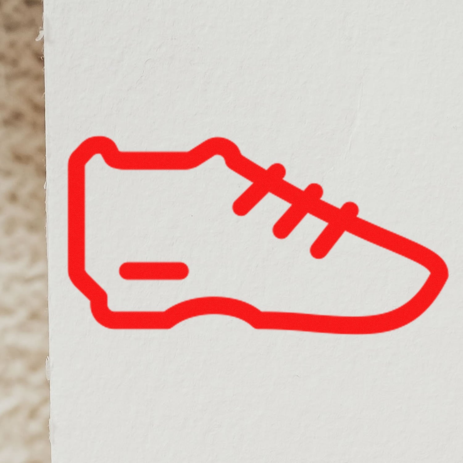 Image of a red sneaker design stamped on paper using the Self-Inking Sneaker Reward Stamp, showcasing its crisp, detailed imprint. Perfect for teachers and sneaker enthusiasts.