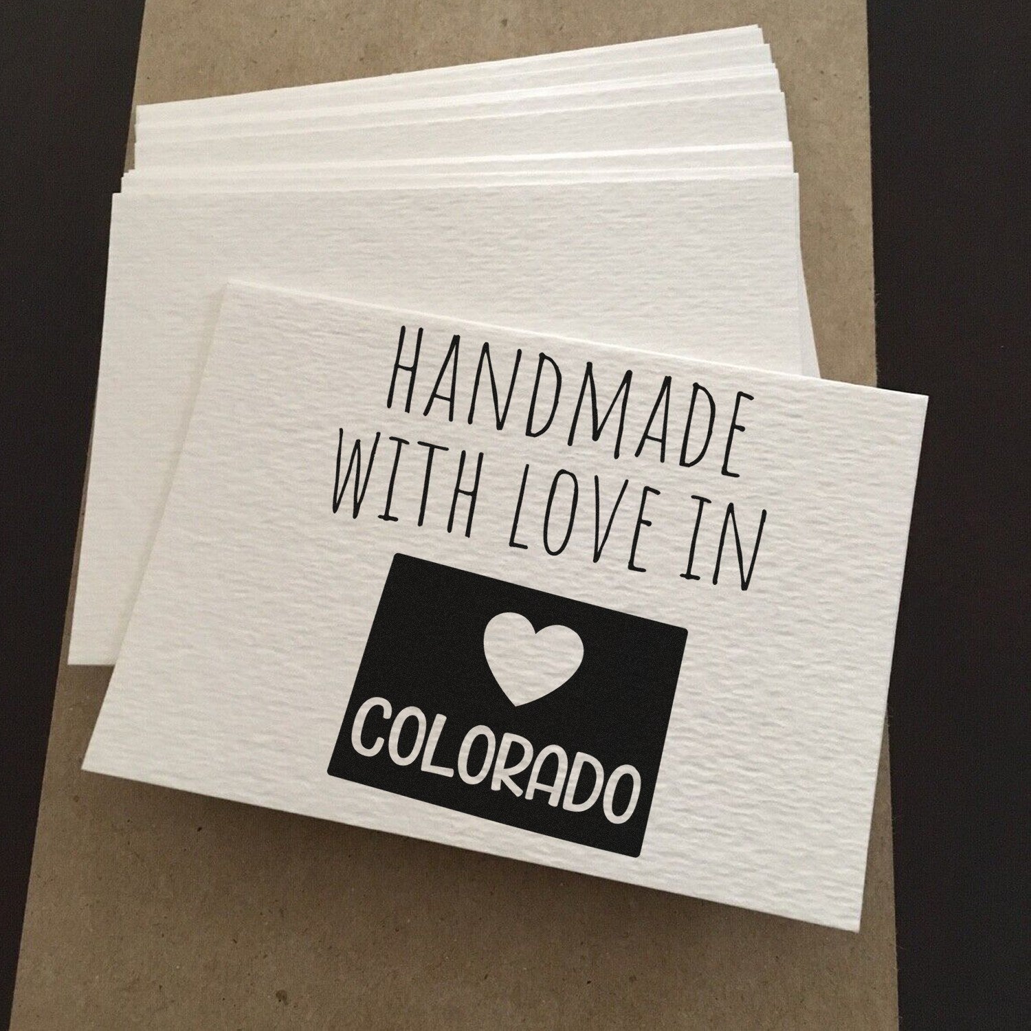 Handmade with Love in Colorado Slim Pre-Inked Stamp on white card, featuring bold black text and heart design, perfect for personalized crafts and gifts.