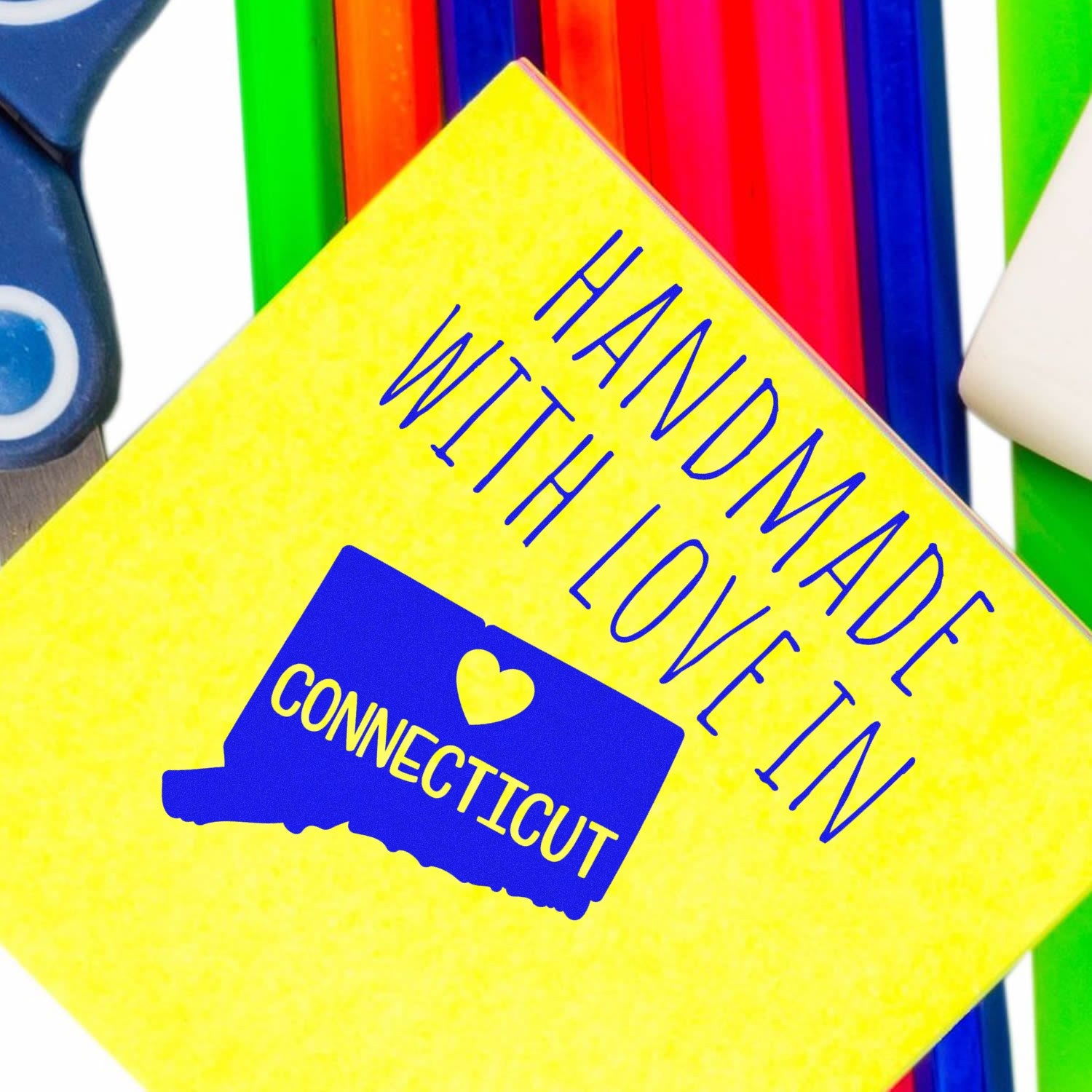 Handmade with Love in Connecticut Slim Pre-Inked Stamp on a vibrant yellow background with colorful pens and scissors.