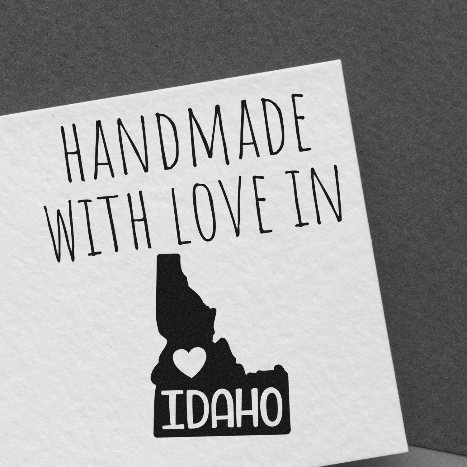 PSI Pre-Inked Handmade with Love in Idaho stamp on white paper, featuring a heart and Idaho state outline, showcasing craftsmanship and personalized design.