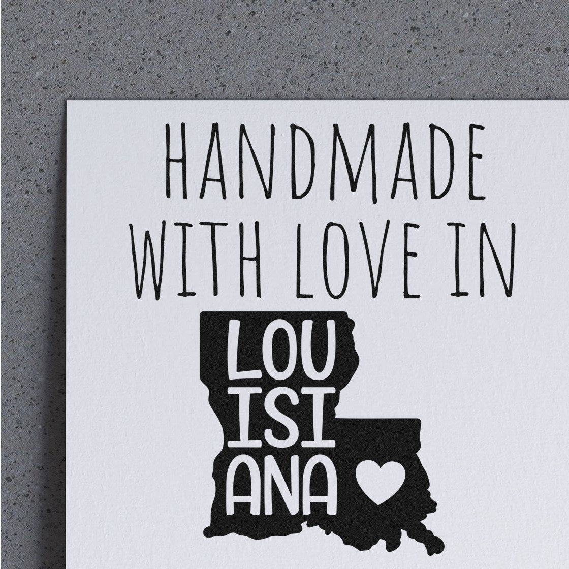 Self-Inking Louisiana Handmade with Love Stamp featuring a Louisiana state outline with 'Handmade with Love in Louisiana' text and heart symbol on a gray background.