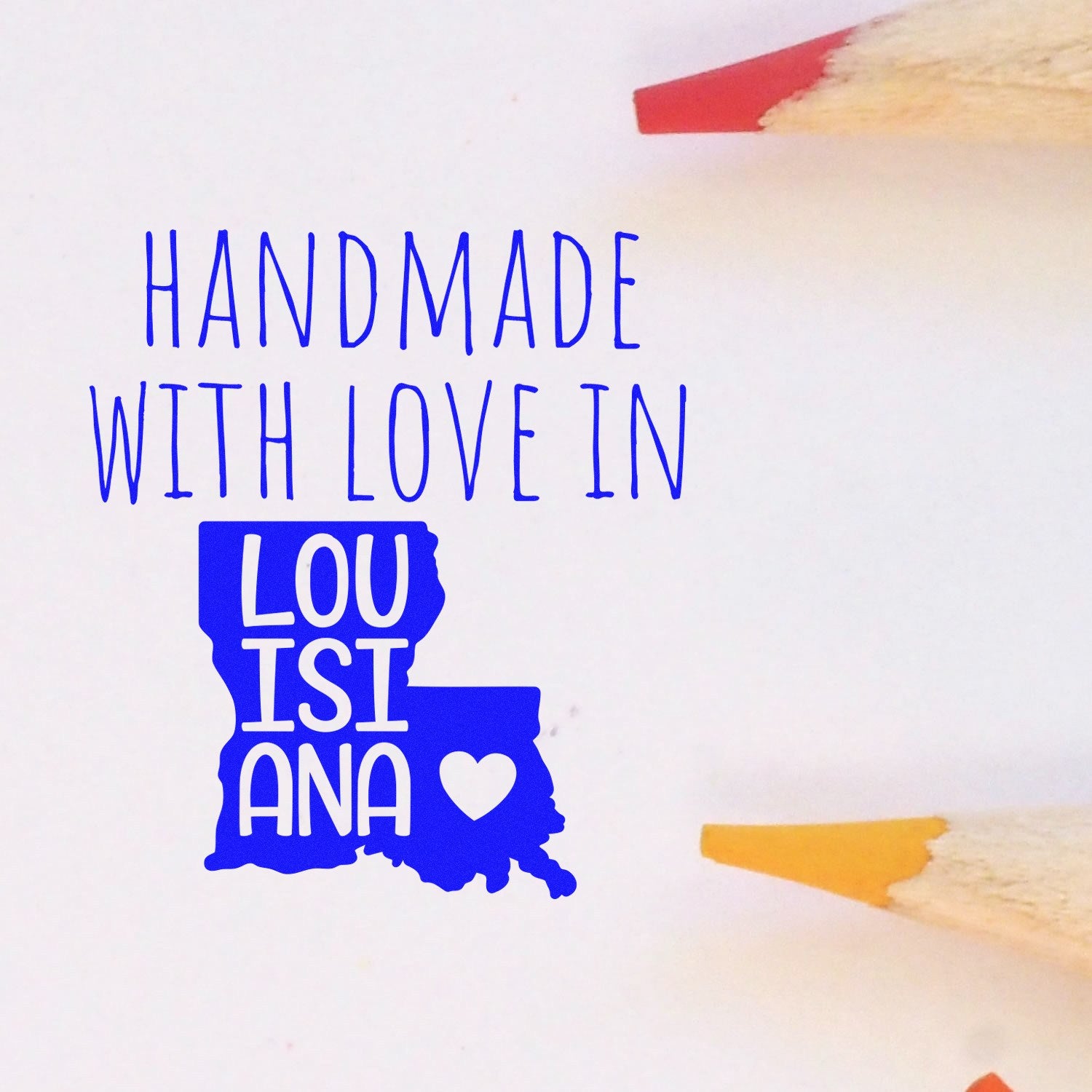 Self-Inking Louisiana Handmade with Love Stamp featuring a blue Louisiana state outline and heart, surrounded by colored pencils on a white background. Perfect for crafts and personalized gifts.