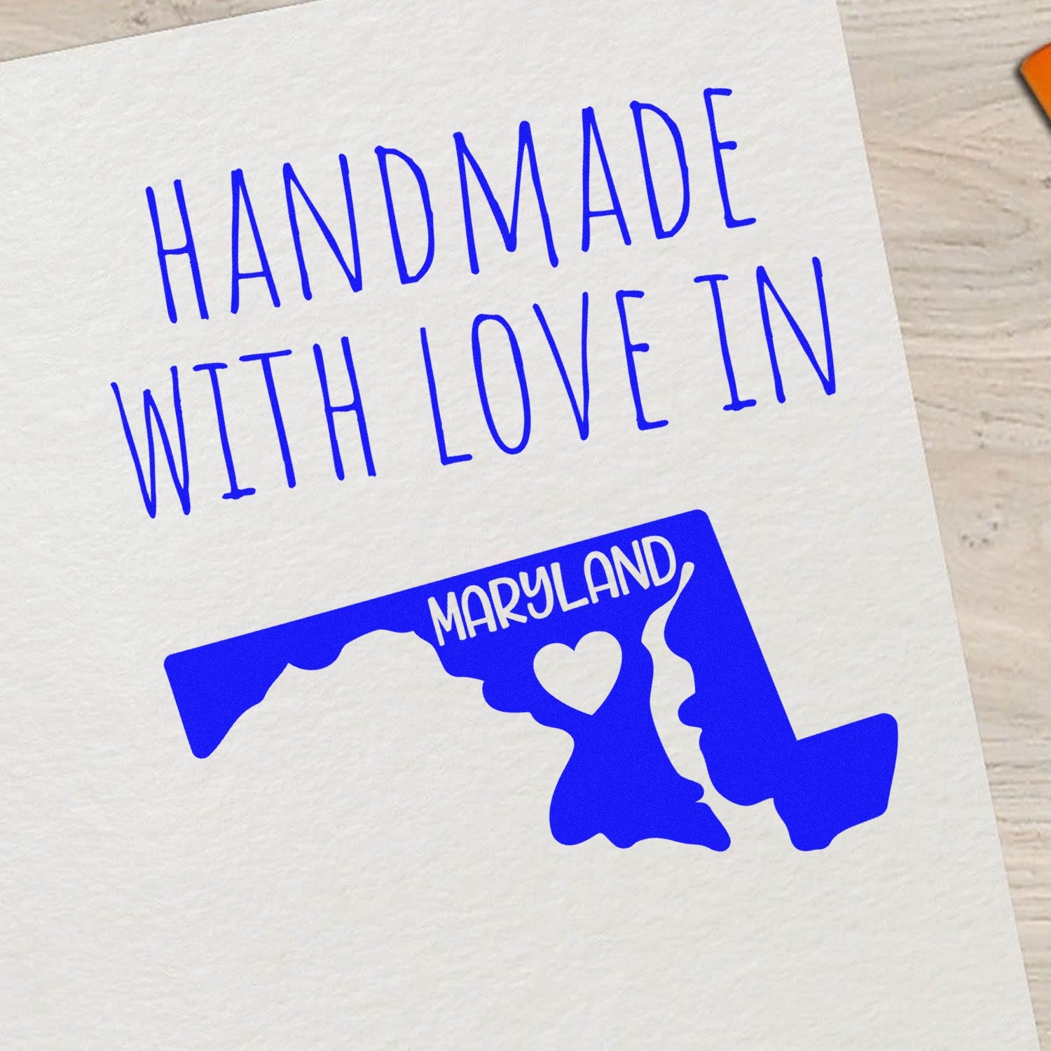 Self-Inking Maryland Handmade with Love Stamp featuring a blue outline of Maryland with a heart, perfect for adding a personal touch to crafts and gifts.