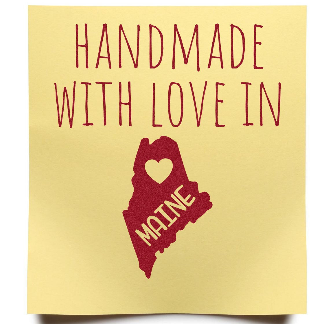 Wood Handle Maine Handmade with Love Rubber Stamp on yellow paper, featuring red text and a heart-shaped Maine outline. Perfect for crafts and personalized projects.