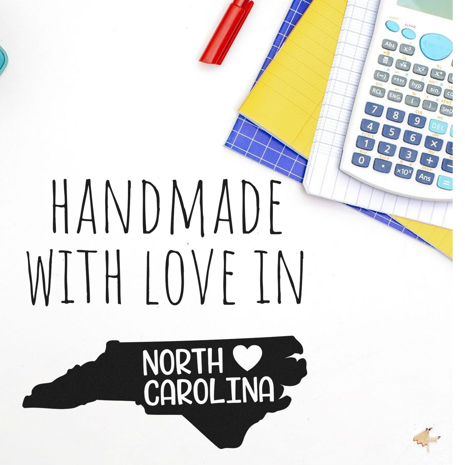 Wood Handle North Carolina Handmade with Love Rubber Stamp on a desk with stationery, featuring a map outline and heart design, perfect for crafts and personalized projects.