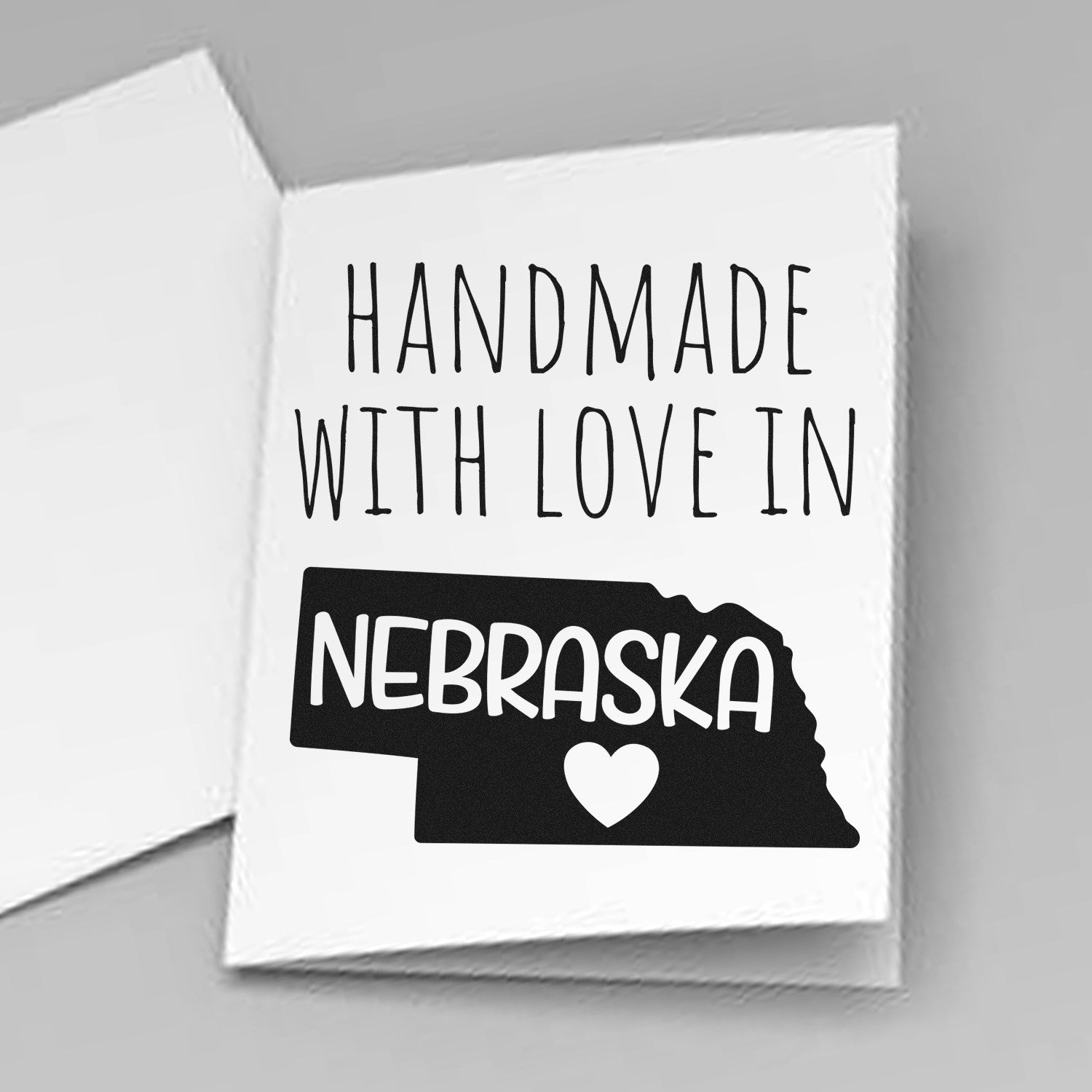 Wood Handle Nebraska Handmade with Love Rubber Stamp on a white card, featuring a black Nebraska state outline with a heart, emphasizing craftsmanship and love.