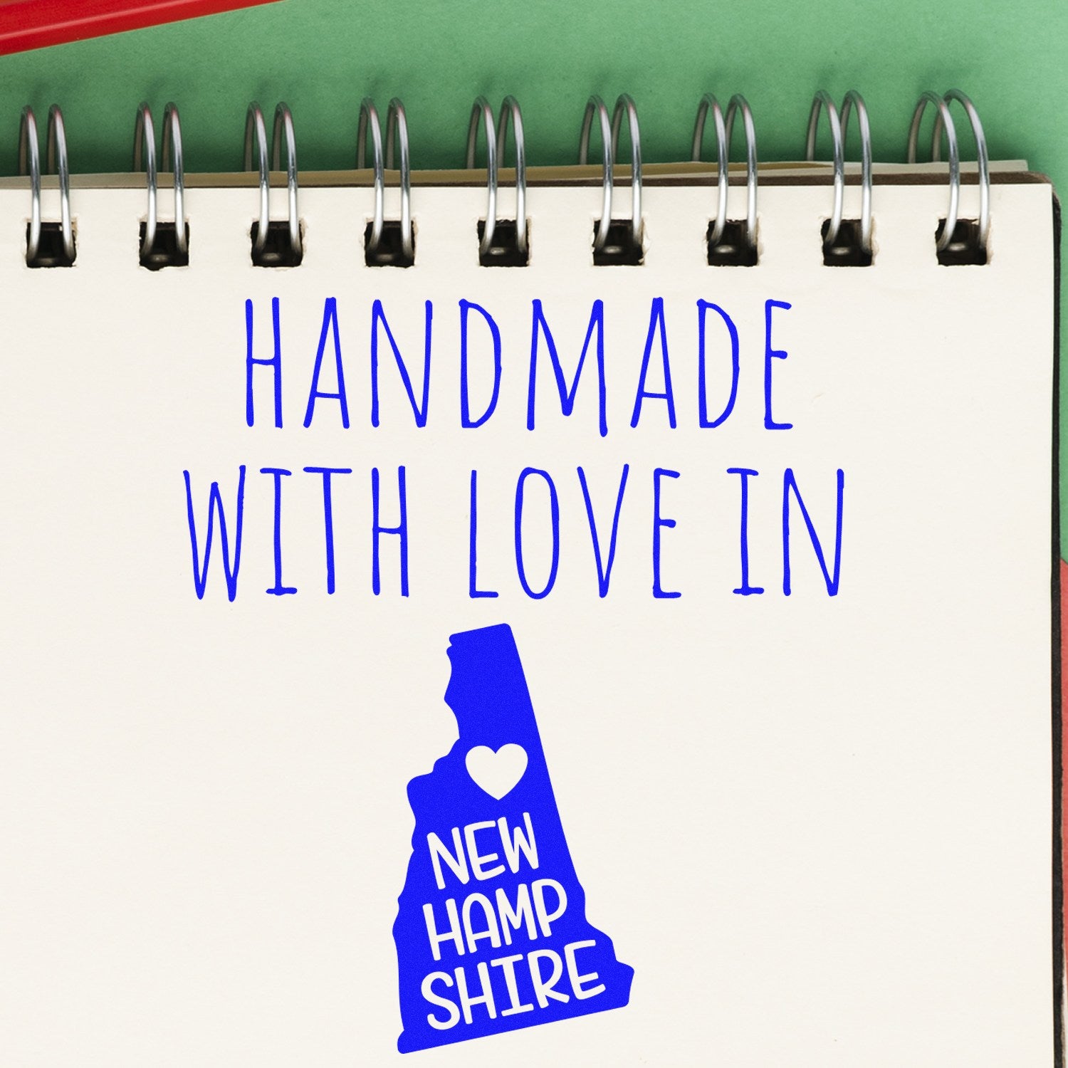 Self-Inking New Hampshire Handmade with Love Stamp featuring a blue state outline and heart, perfect for crafts and gifts. Ideal for adding a personal touch to your projects.