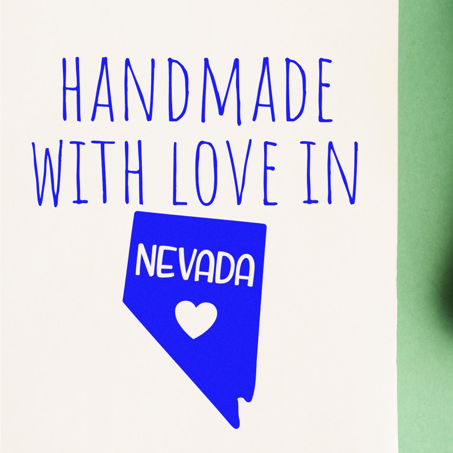 Handmade with Love in Nevada Slim Pre-Inked Stamp featuring a blue Nevada state outline with a heart, perfect for adding a personal touch to crafts and stationery.