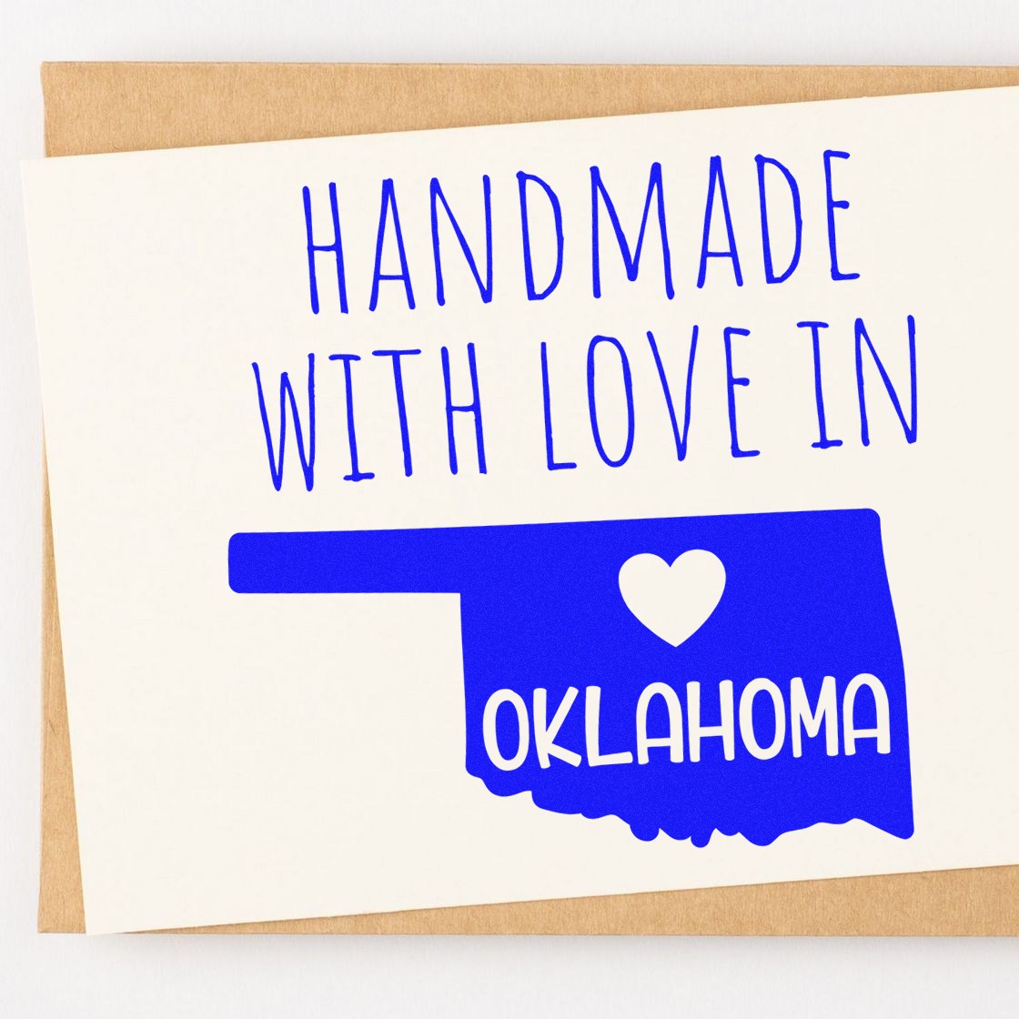 PSI Pre-Inked Handmade with Love in Oklahoma stamp on a card, featuring a blue Oklahoma state outline with a heart. Perfect for adding a personal touch to crafts and gifts.