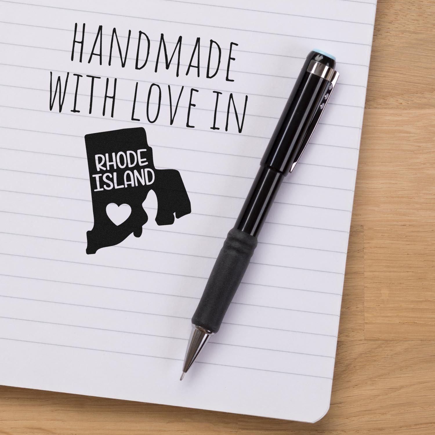 Handmade with Love in Rhode Island Slim Pre-Inked Stamp on notepad with pen, featuring a heart design within the state outline.