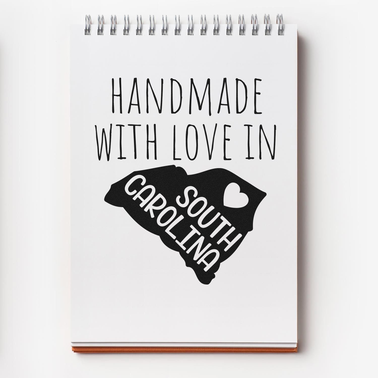 Self-Inking South Carolina Handmade with Love Stamp on notepad, featuring a heart and state outline. Perfect for crafts and gifts.