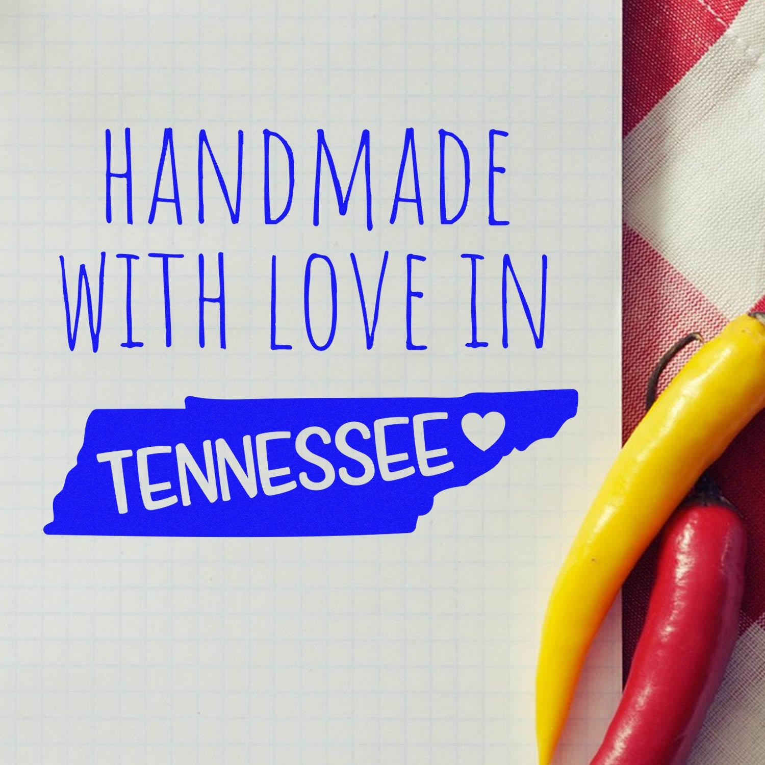 Wood Handle Tennessee Handmade with Love Rubber Stamp on a checkered cloth background, featuring a blue design with the text Handmade with Love in Tennessee and a heart symbol.