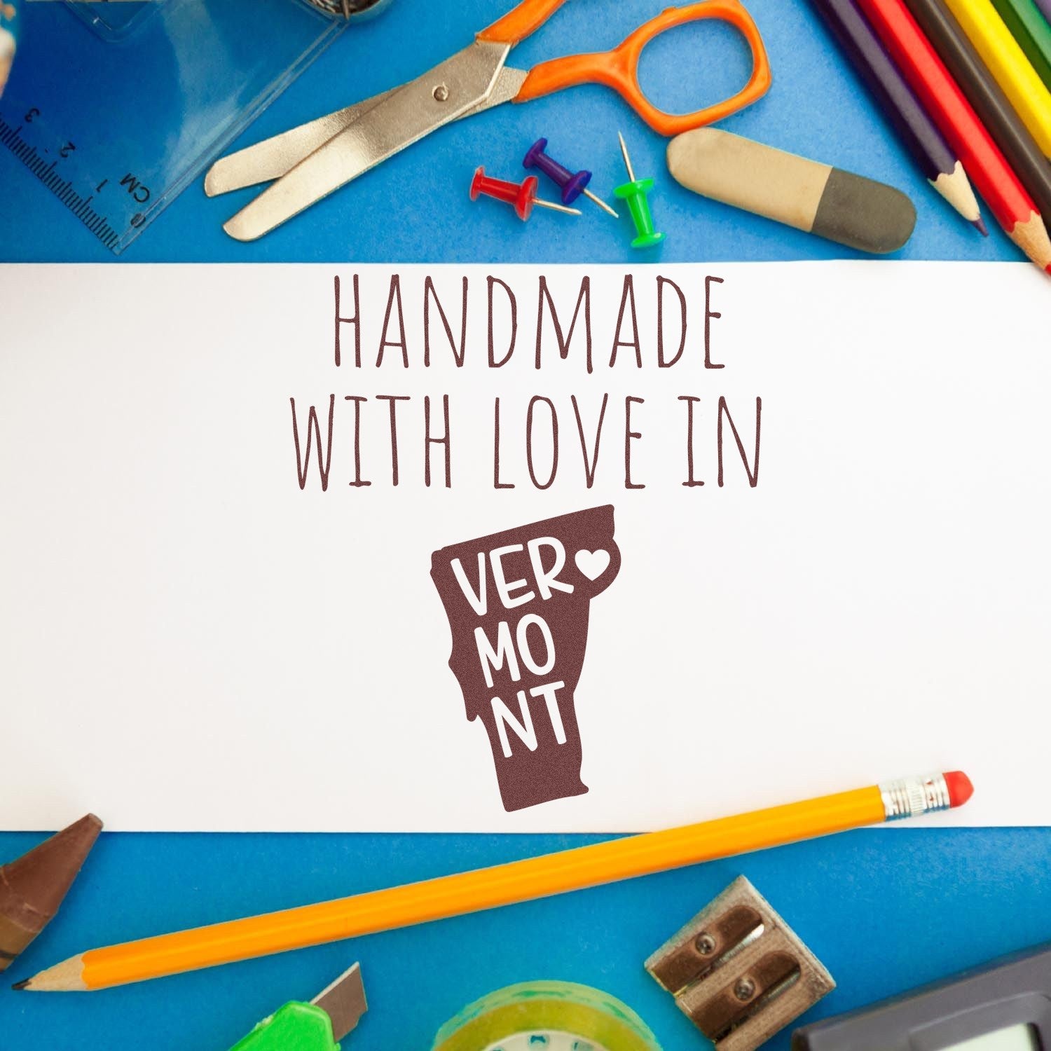 Wood Handle Virginia Handmade with Love Rubber Stamp on a blue desk surrounded by colorful stationery, featuring a Handmade with Love in Vermont imprint.