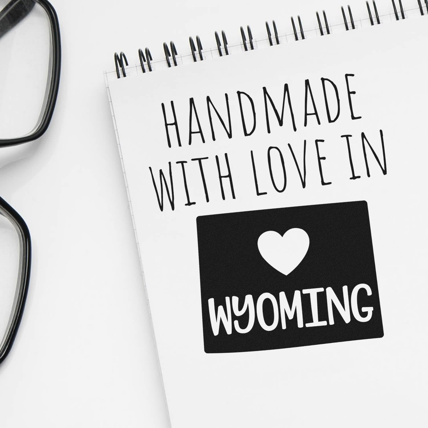 Handmade with Love in Wyoming Slim Pre-Inked Stamp on notepad, featuring a heart and 'Wyoming' text, perfect for personalized crafts and gifts.